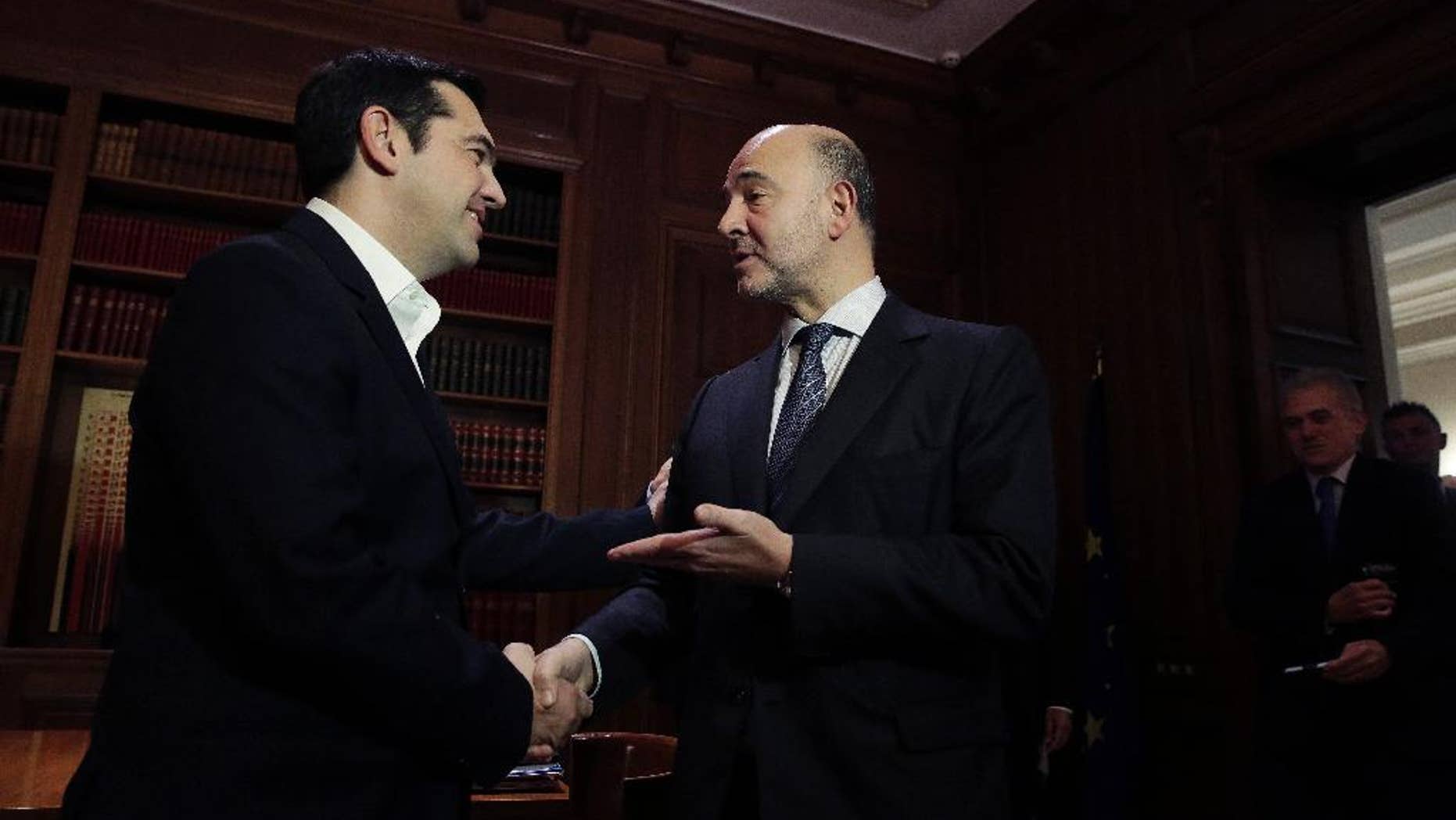 Greek Prime Minister Alexis Tsipras, left, meets with European Commissioner for Economic and Financial Affairs Pierre Moscovici in Athens, on Tuesday, Nov. 3, 2015. Moscovici's talks with officials in Greece's leftwing government will focus on the progress of reforms demanded by the country's European creditors in return for a third multi-billion euro bailout. (AP Photo/Petros Giannakouris)
