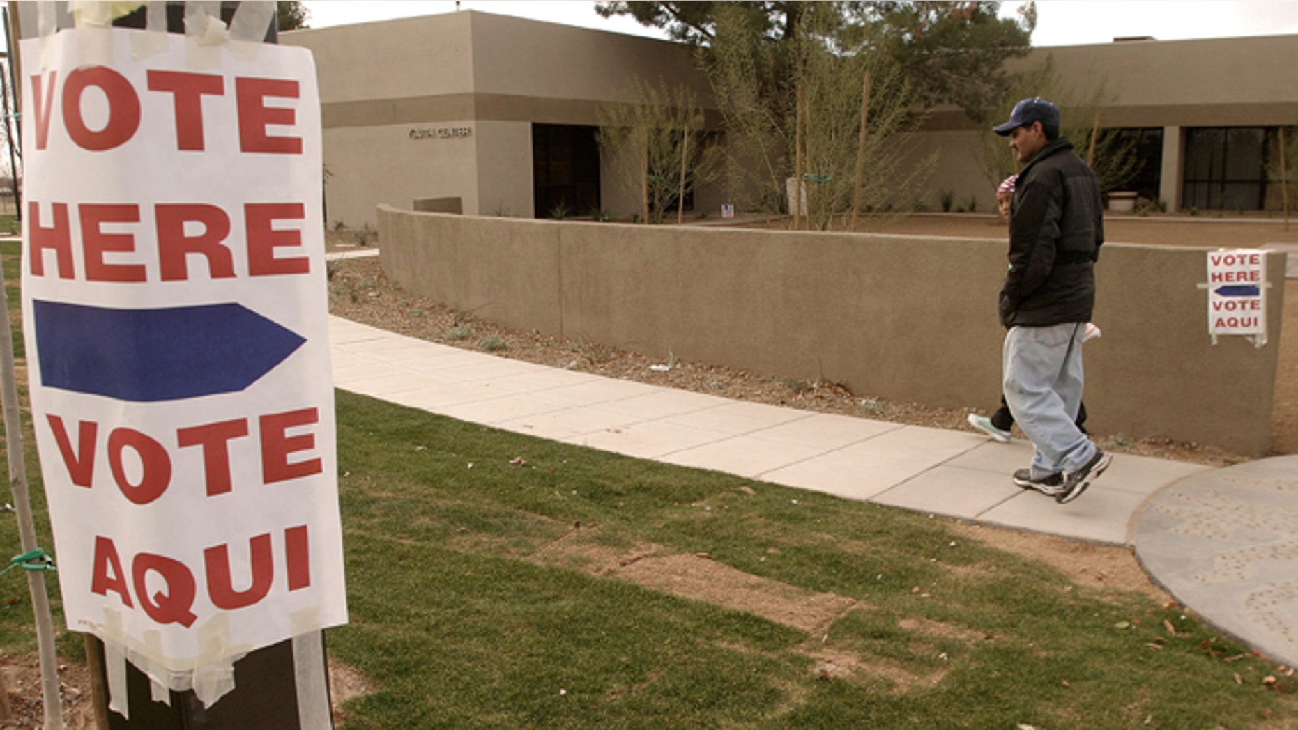 Lupe Montoya (wearing cap) and his neighbor Juana Nicholas, of El Mirage, Arizona walk to the El Mirage Youth Center, February 3, 2004 where they will vote in the state's democratic presidential primary election. (Photo by Jeff Topping/Getty Images)