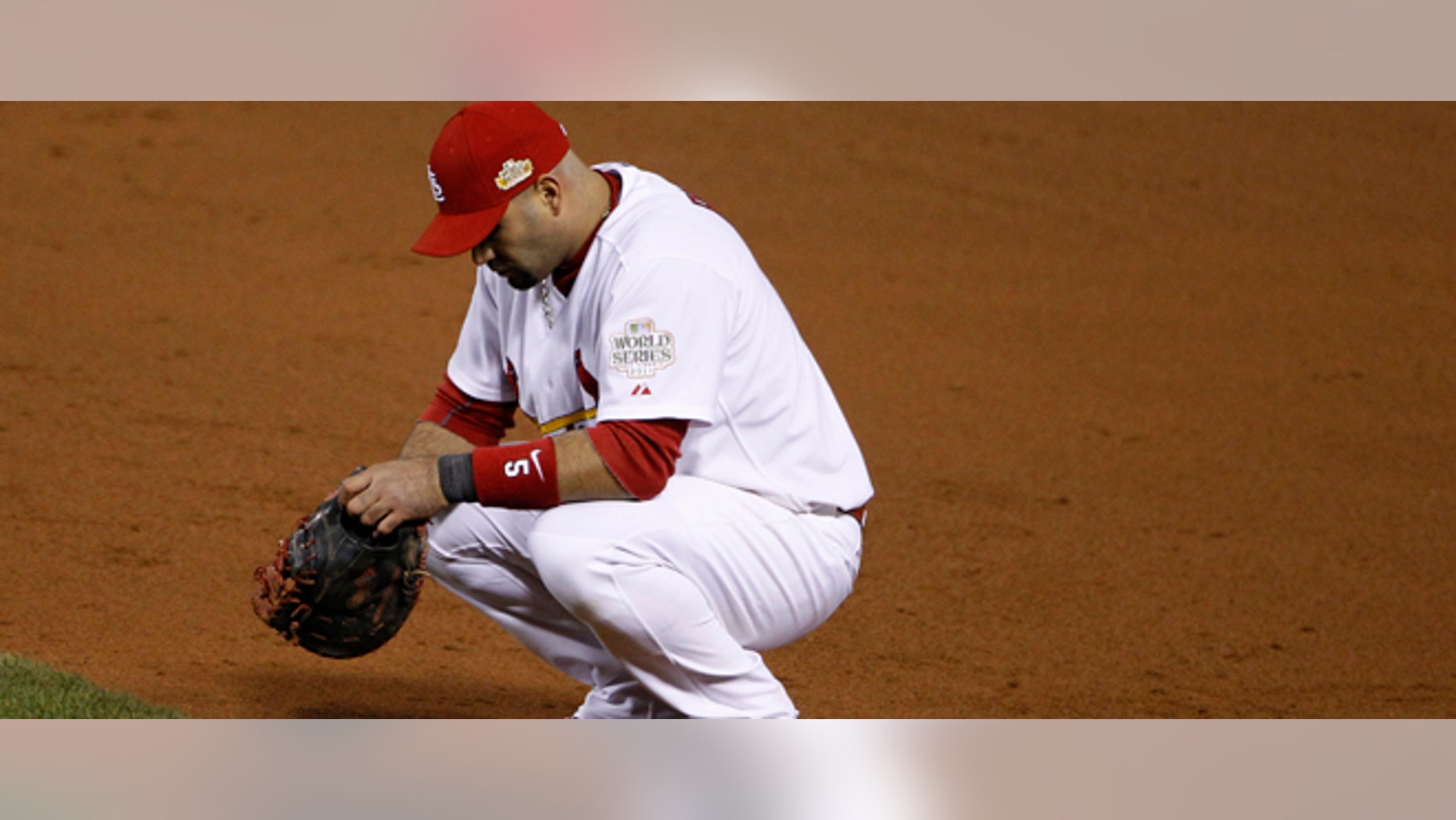 St. Louis Cardinals' Albert Pujols pauses during a pitching change during the ninth inning of Game 2 of baseball's World Series against the Texas Rangers Thursday, Oct. 20, 2011, in St. Louis. (AP Photo/Eric Gay)