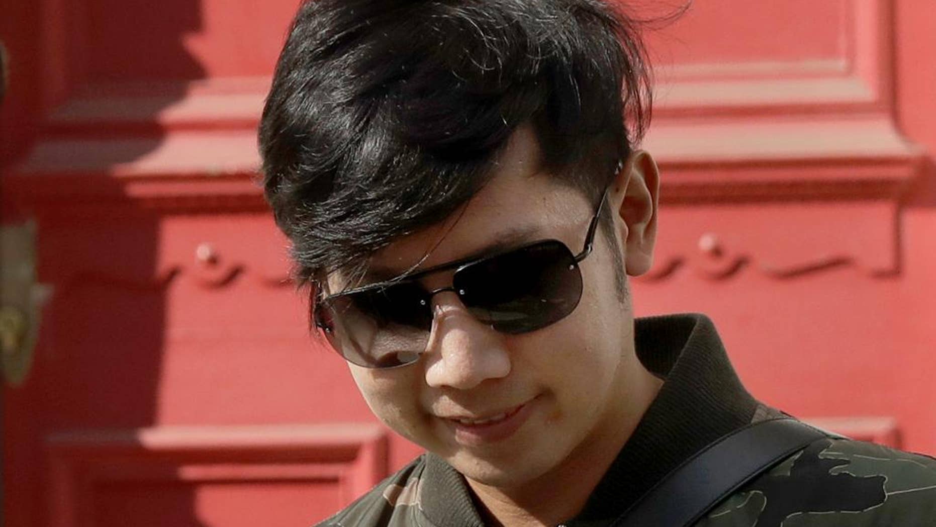 FILE - In this Wednesday, April 15, 2017, file photo, Vorayuth "Boss" Yoovidhya, whose grandfather co-founded energy drink company Red Bull, walks to get in a car as he leaves a house in London. Thai authorities who’ve issued an arrest warrant for the Red Bull heir accused of an alleged hit-and-run that killed a police officer almost five years ago, flew from Bangkok to Singapore two days before he was supposed to appear before prosecutors. (AP Photo/Matt Dunham, File)