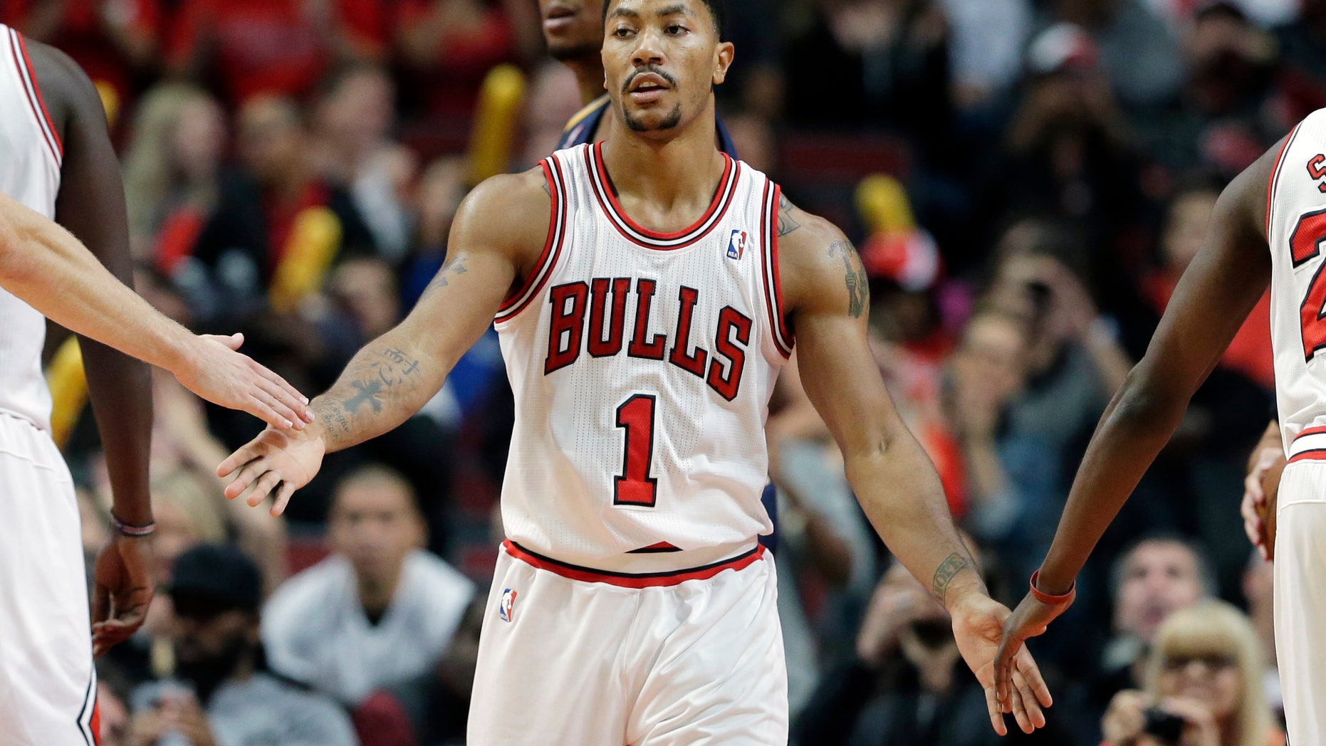 Chicago Bulls guard Derrick Rose (1) celebrates with teammates after scoring a free-throw shot during the second half of an NBA preseason basketball game against the Indiana Pacers in Chicago on Friday, Oct. 18, 2013. the Bulls won 103-98. (AP Photo/Nam Y. Huh)