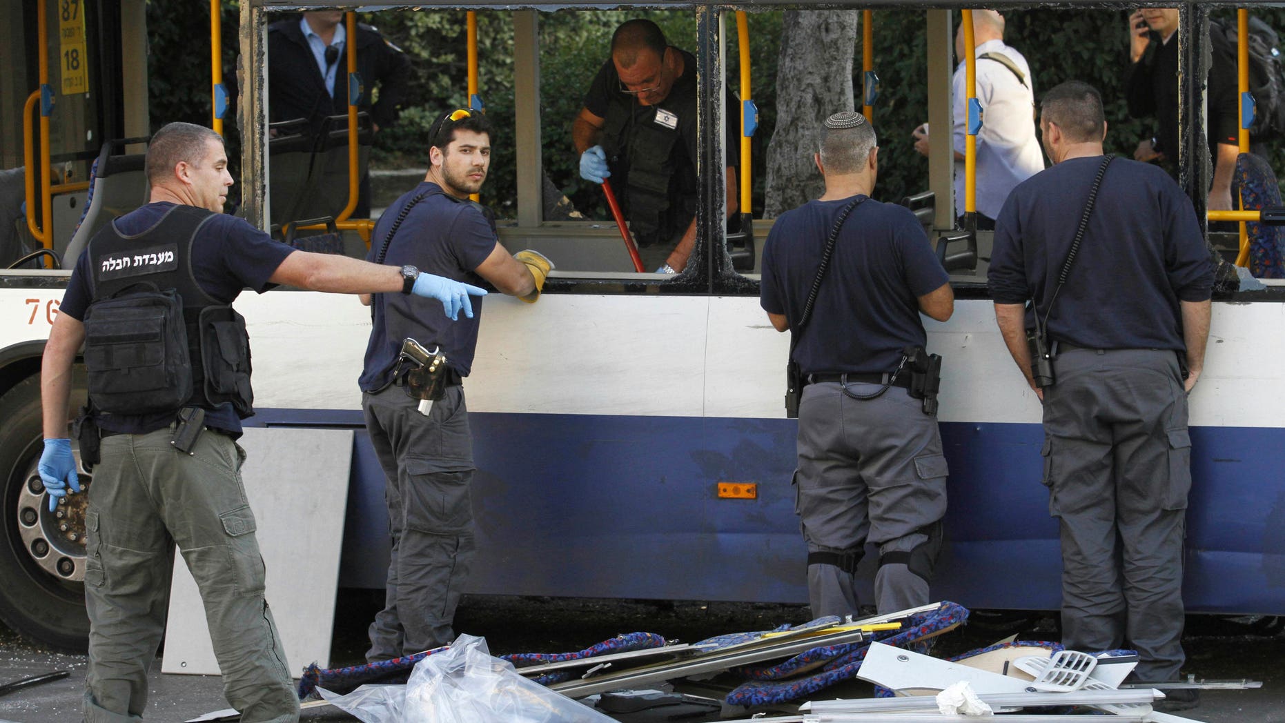 Israeli policemen inspect a bus after an explosive device detonated in a Tel Aviv suburb, Sunday, Dec. 22, 2013. A small bomb exploded on board the bus just moments after it had been evacuated on Sunday, police said, adding that an initial investigation suggests that Palestinian militants were behind the attack. (AP Photo/Tomer Appelboum) ISRAEL OUT