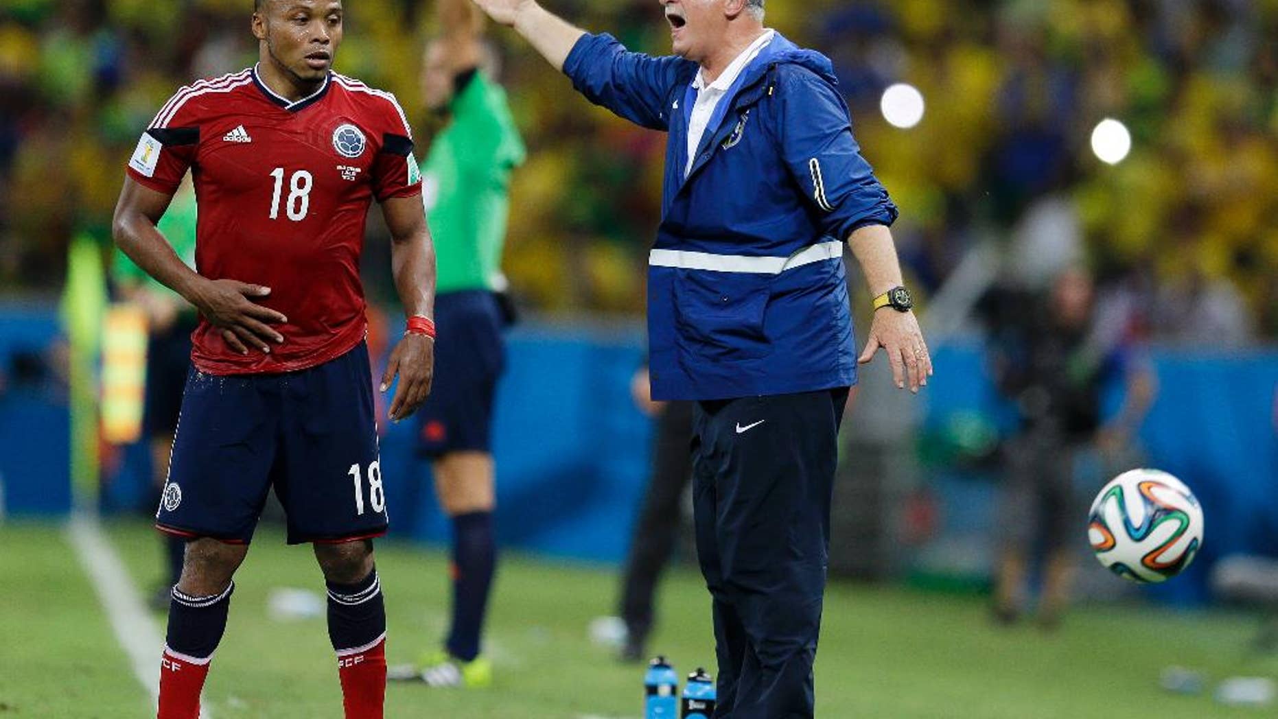 Colombia's Juan Zuniga waits to get the ball as Brazil's coach Luiz Felipe Scolari yells instructions to his players during the World Cup quarterfinal soccer match between Brazil and Colombia at the Arena Castelao in Fortaleza, Brazil, Friday, July 4, 2014. Brazil defeated Colombia 2-1 to advance to the semifinals. (AP Photo/Natacha Pisarenko)