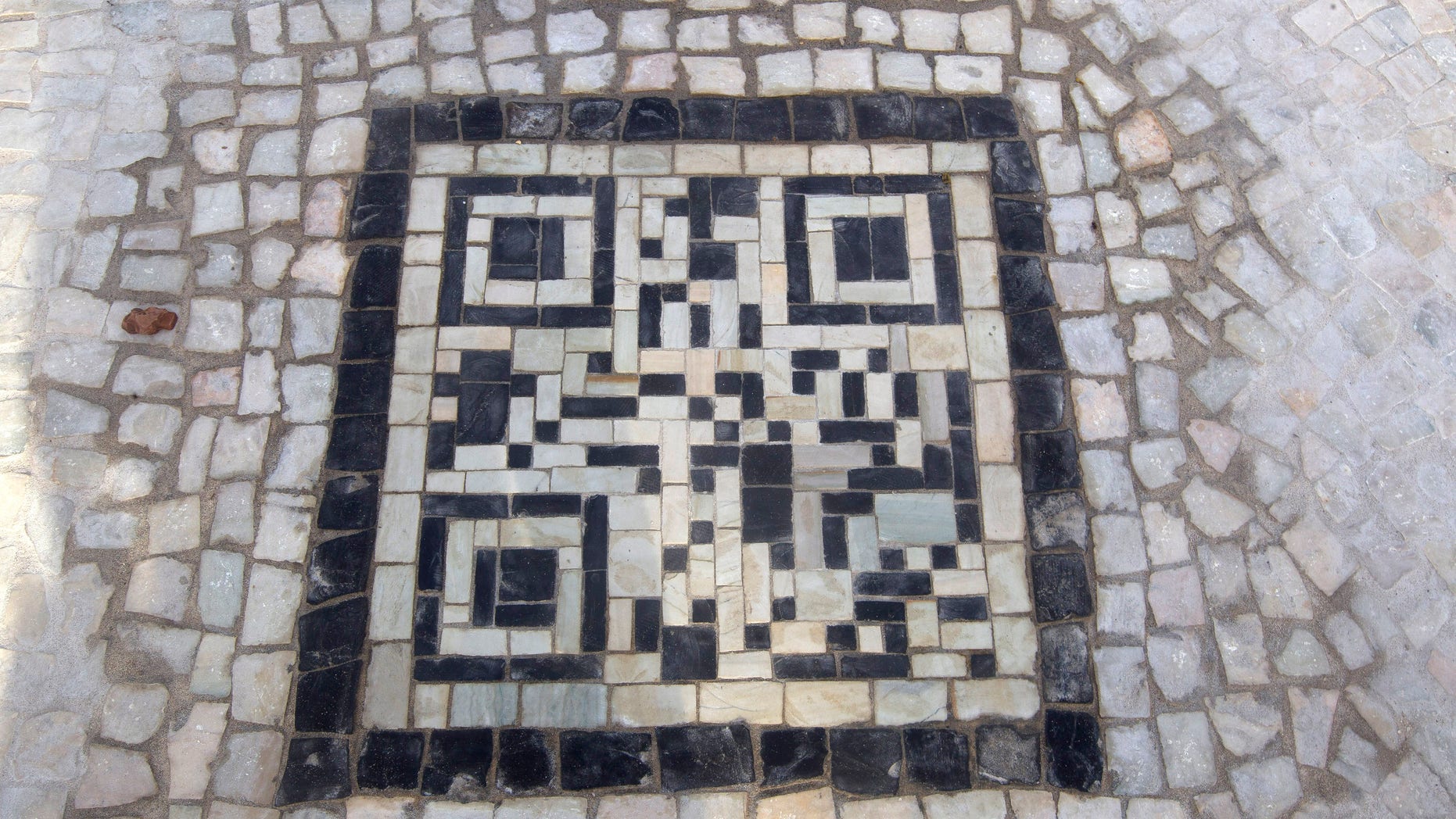 A two-dimensional bar code, or QR code, as they're known, made from black and white stones covers a sidewalk near the beach in Rio de Janeiro, Brazil, Friday, Jan. 25, 2013. The QR codes are being placed at tourist spots which can be scanned with a mobile device for information about the site. (AP Photo/Silvia Izquierdo)