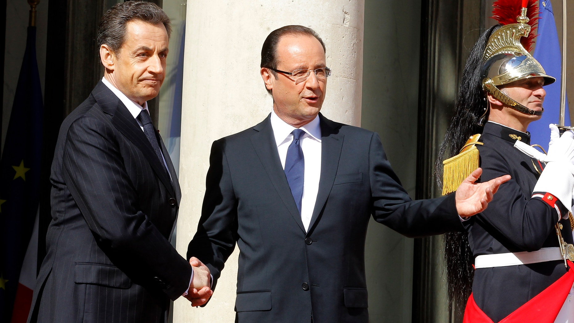 May 15, 2012: French President-elect Francois Hollande, right, shakes hands with outgoing President Nicolas Sarkozy.