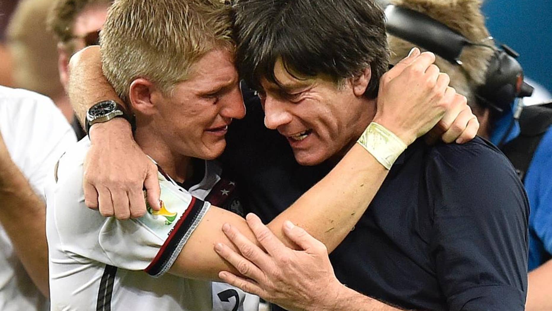 Germany's Bastian Schweinsteiger and Germany's head coach Joachim Loew embrace after the World Cup final soccer match between Germany and Argentina at the Maracana Stadium in Rio de Janeiro, Brazil, Sunday, July 13, 2014. Germany won the match 1-0 (AP Photo/Martin Meissner)