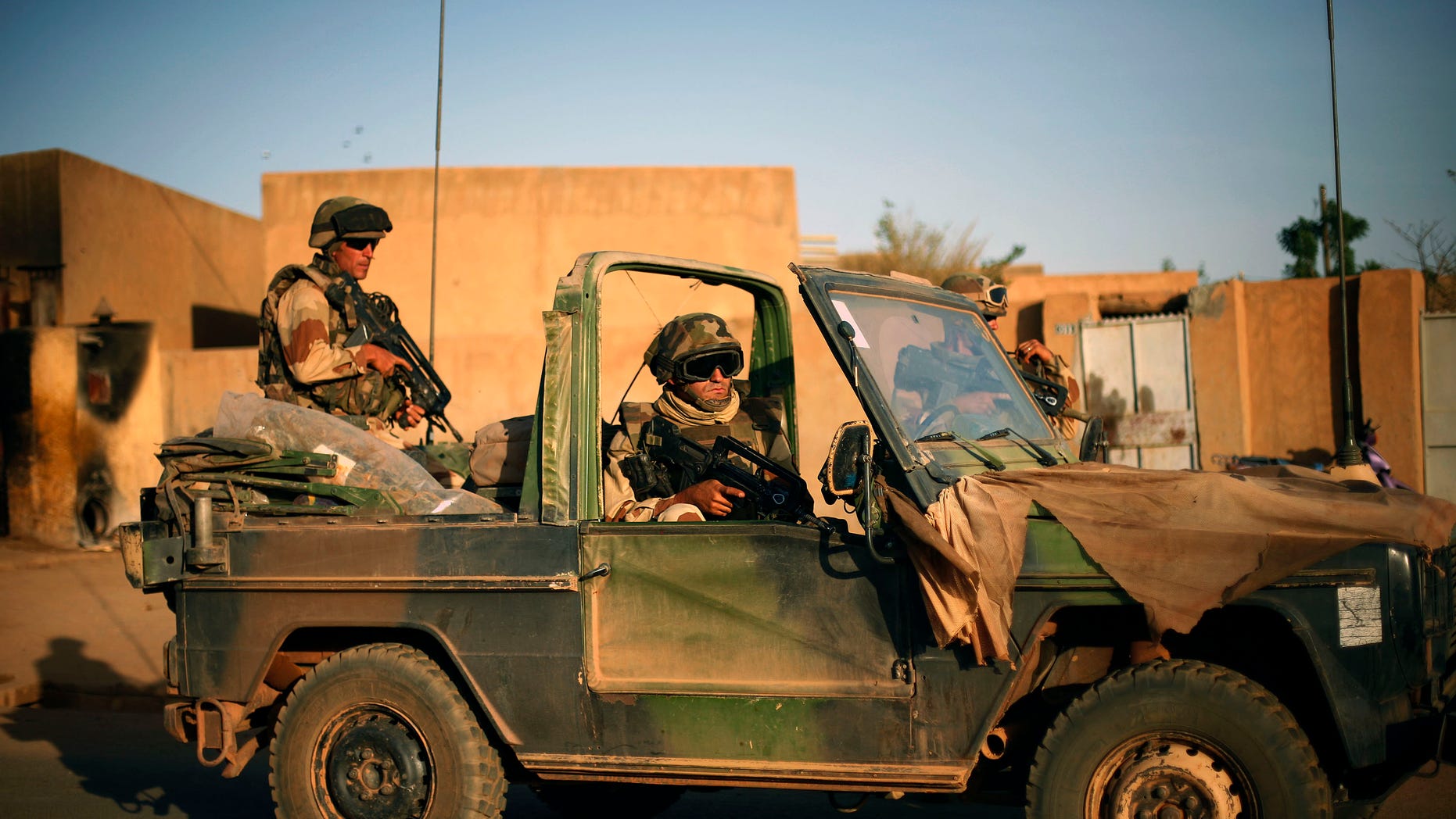 French soldiers secure the evacuation of foreigners during exchanges of fire with jihadists in Gao, northern Mali, Sunday, Feb. 10, 2013. Black-robed Islamic extremists, armed with AK-47 automatic rifles and rocket-propelled grenades, invaded the northern Mali city of Gao and fought Malian army forces Sunday. (AP Photo/Jerome Delay)