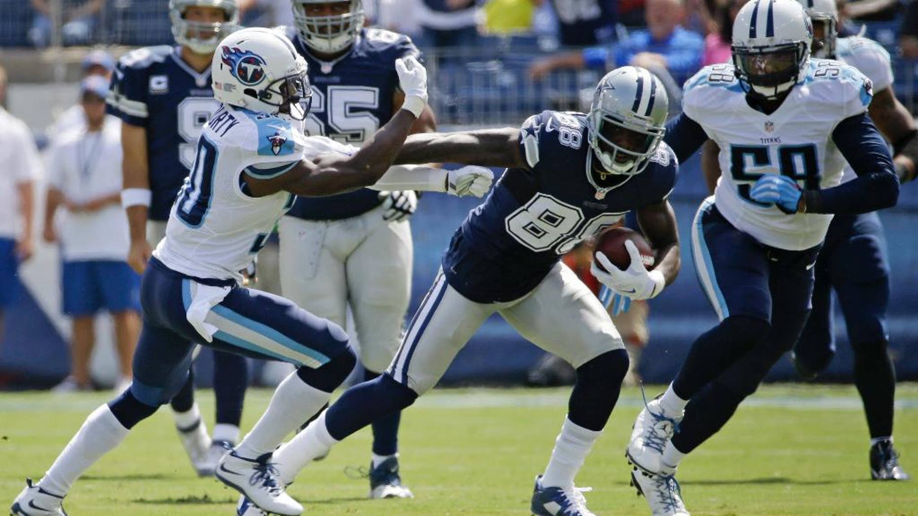 Dallas Cowboys wide receiver Dez Bryant (88) tries to get past Tennessee Titans cornerback Jason McCourty (30) in the first quarter of an NFL football game Sunday, Sept. 14, 2014, in Nashville, Tenn. (AP Photo/Wade Payne)