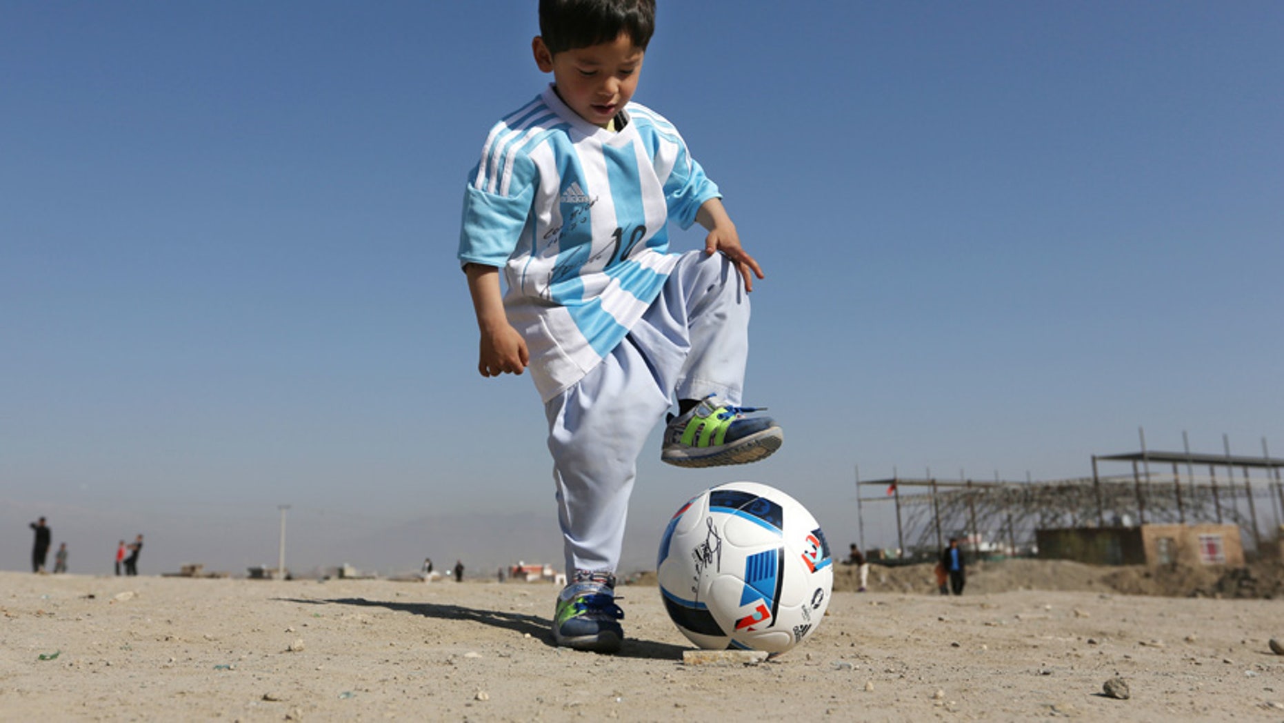 Feb. 26, 2016: Murtaza Ahmadi, a five-year-old Afghan Lionel Messi fan plays with a soccer ball during a photo opportunity as he wears a shirt signed by Messi, in Kabul, Afghanistan.