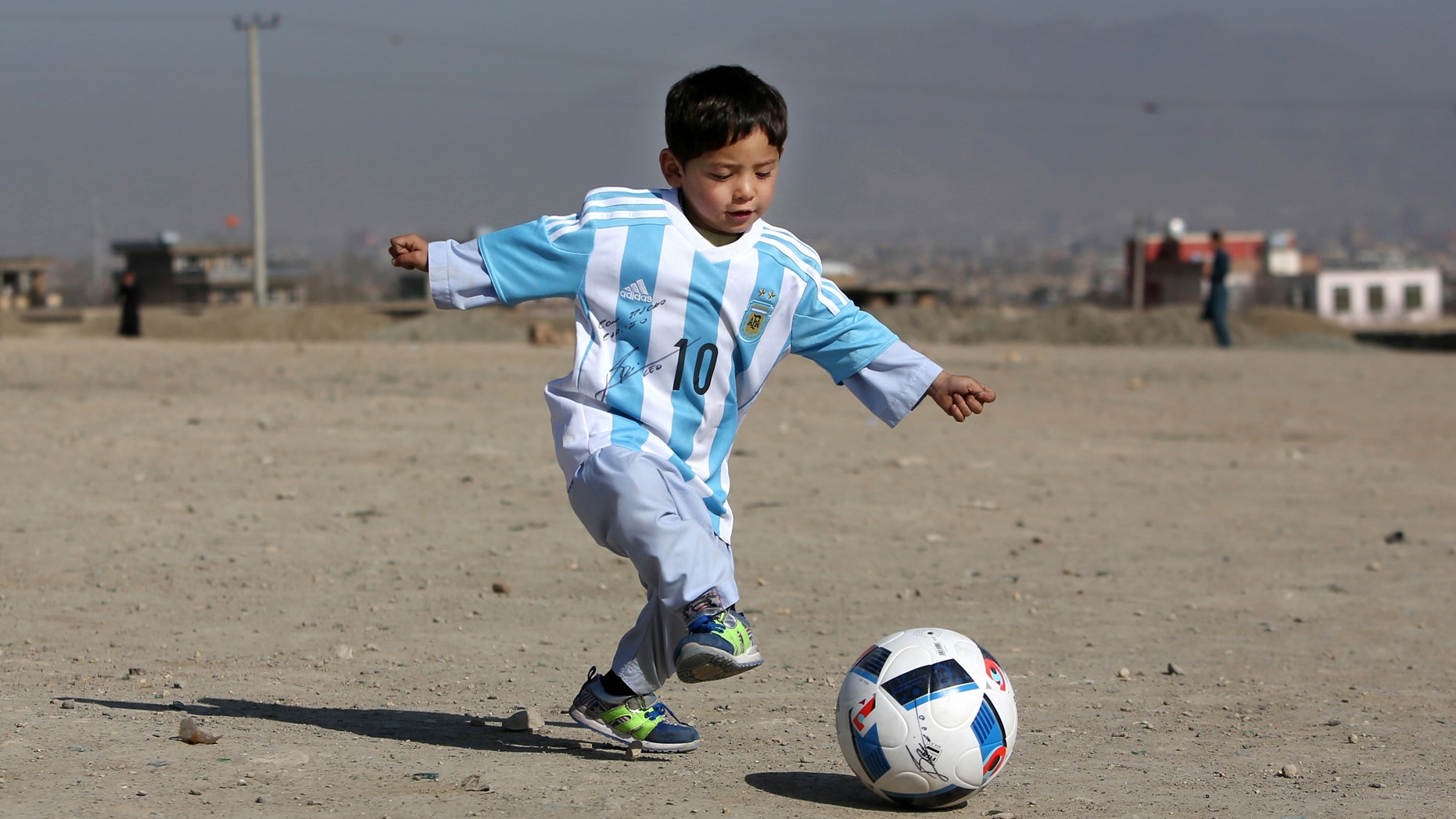 Murtaza Ahmadi, a five-year-old Afghan Lionel Messi fan playing with a soccer ball during a photo opportunity in Kabul, Afghanistan