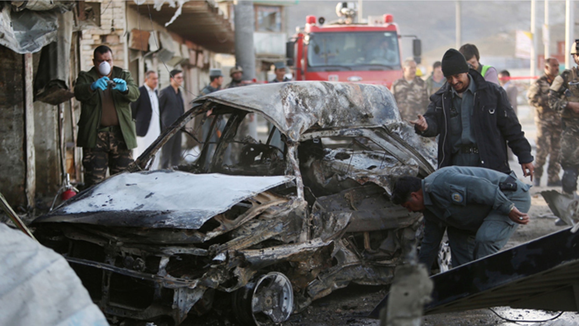 April 10, 2015: Afghan security personnel gather at the site of a suicide attack in Kabul, Afghanistan.