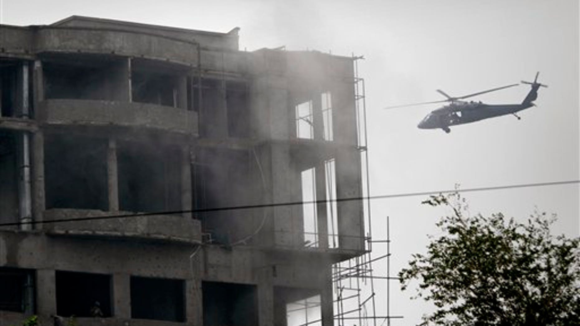 Sept. 14: A military helicopter belonging to coalition forces flies around a building during a gun battle with Taliban militants in Kabul, Afghanistan. The 20-hour insurgent attack in the heart of Kabul ended Wednesday morning after a final volley of helicopter gunfire as Afghan police ferreted out and killed the last few assailants who had taken over a half-built downtown building to fire on the nearby U.S. Embassy and NATO compounds.