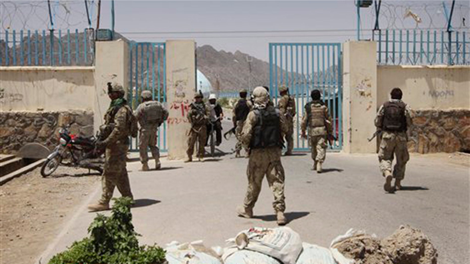 U.S. soldiers, left, and Afghan Police Commando forces, right, are seen at a university after a bomb blast in Kandahar, Afghanistan, on June 4.