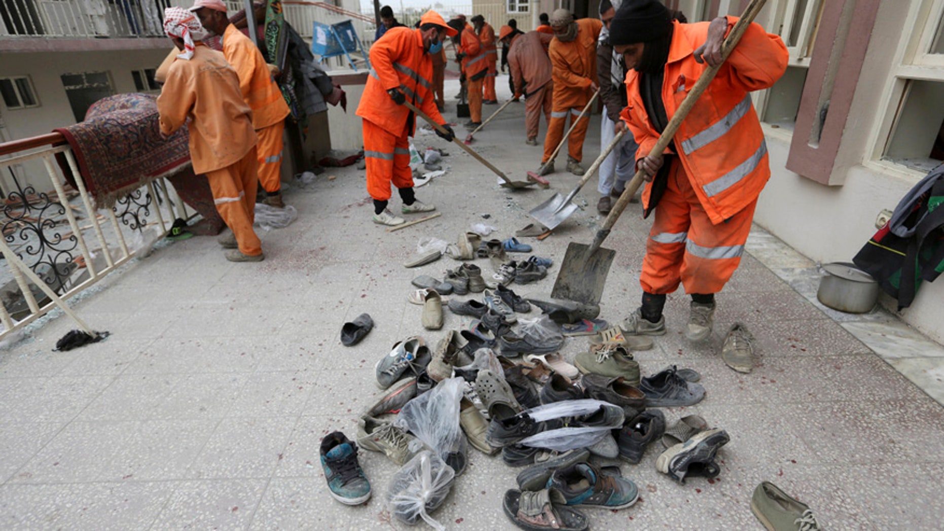 Nov. 21, 2016: Afghan Municipality workers collect shoes of victims in front the Baqir-ul Ulom mosque after a suicide attack, in Kabul, Afghanistan.