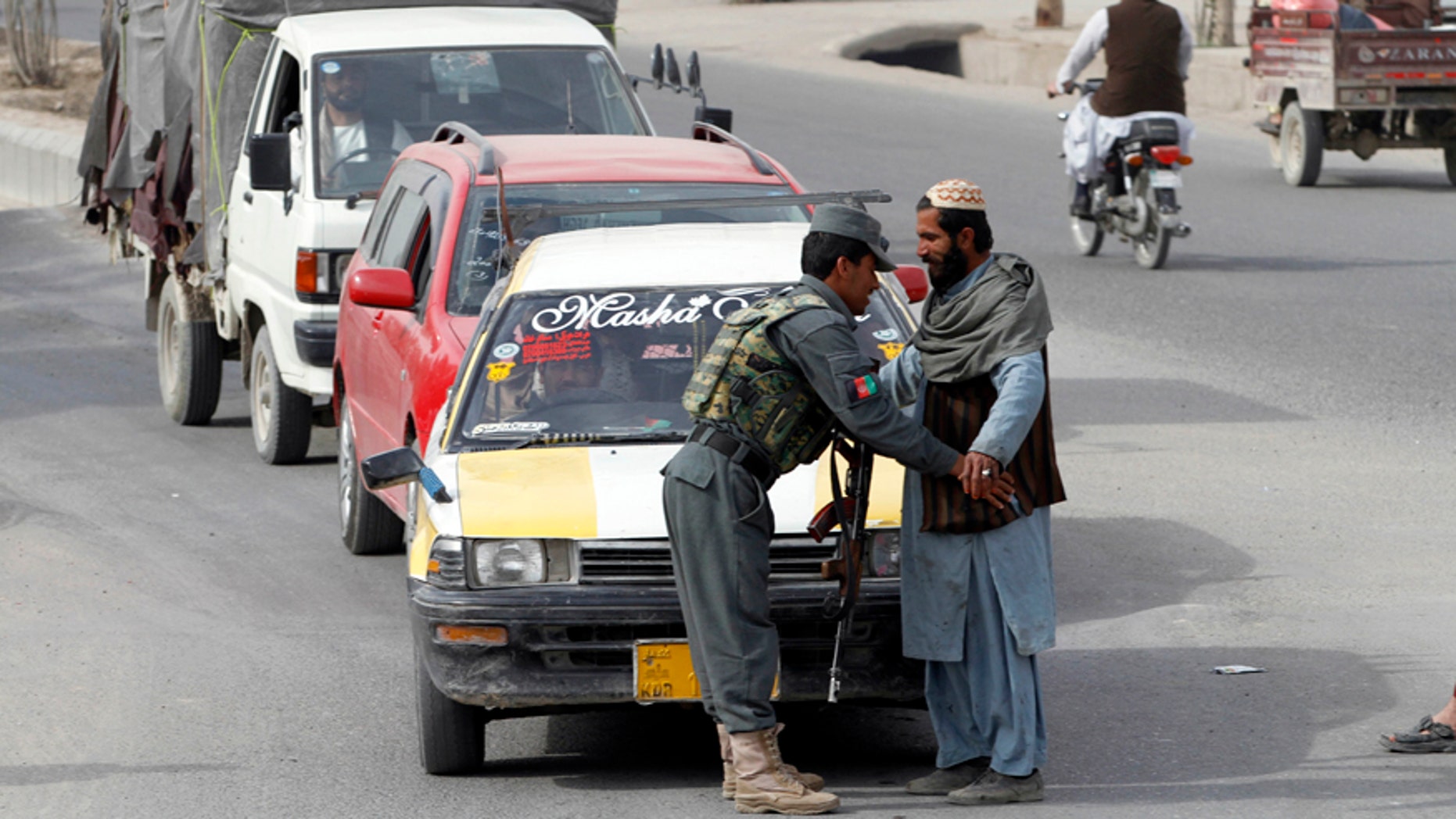 Jan. 26, 2016: An Afghan policeman searches a passenger at a checkpoint in Kandahar, Afghanistan.