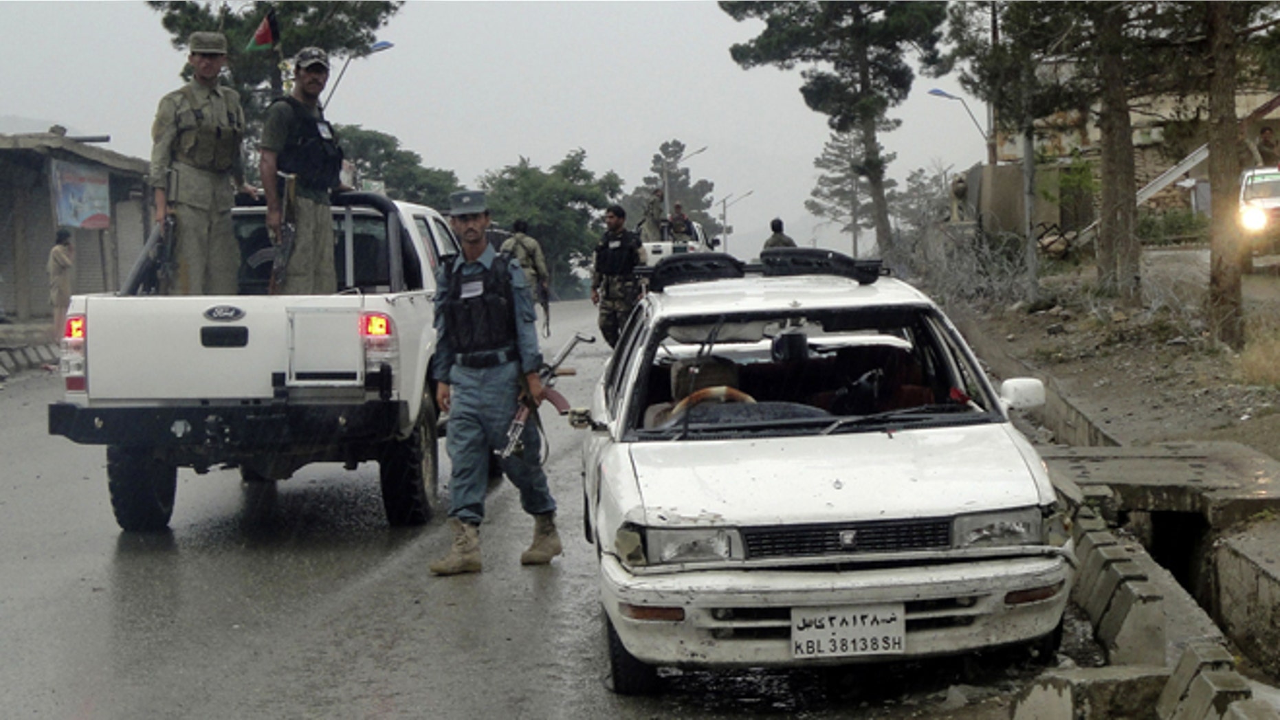 June, 3, 2013: An Afghan policeman walks past a vehicle as he investigates the aftermath of a suicide bomb attack, in Paktia Province, east of Kabul, Afghanistan. A suicide bomber targeting an American military delegation outside a government office in eastern Afghanistan killed more than a dozen on Monday, including many schoolchildren who were walking nearby and two international service members, officials said.