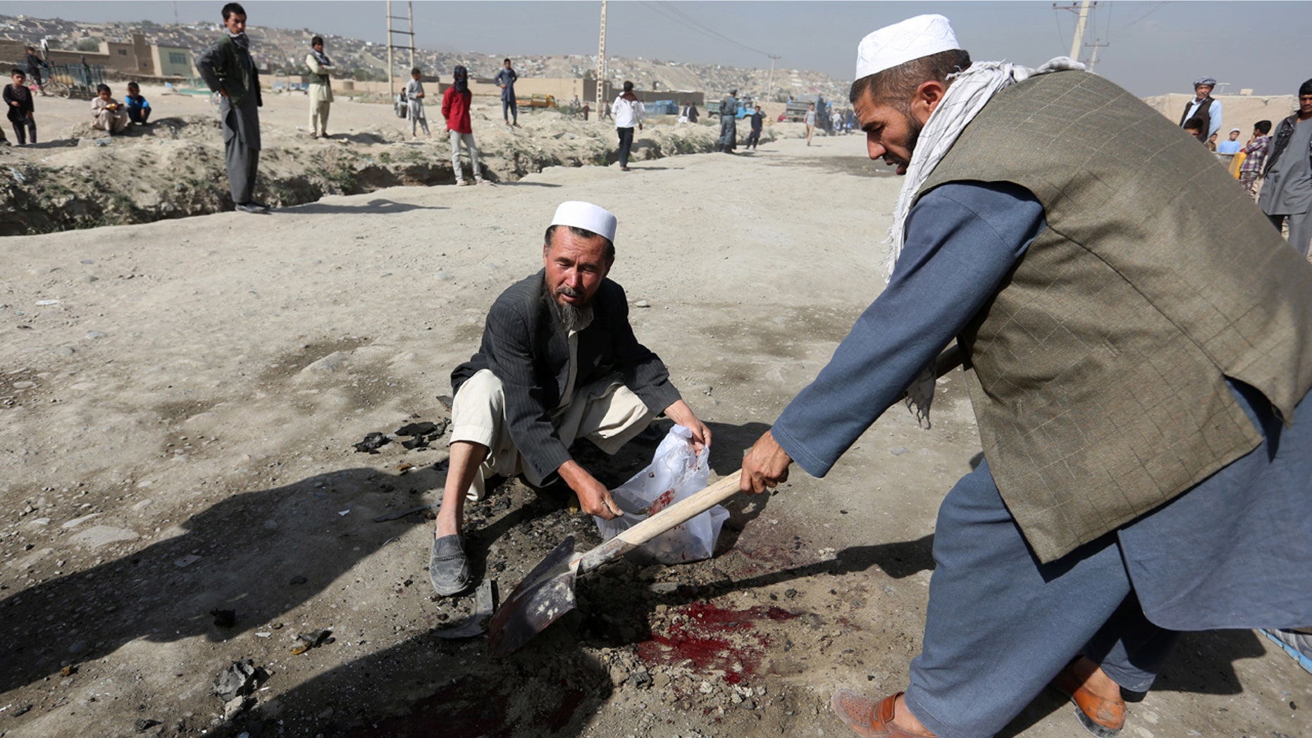 Aug. 20, 2016: Afghan men clean the site of a bomb blast on the outskirts of Kabul. A soldier was killed early Saturday by a sticky bomb placed on his vehicle, Kabul police said.