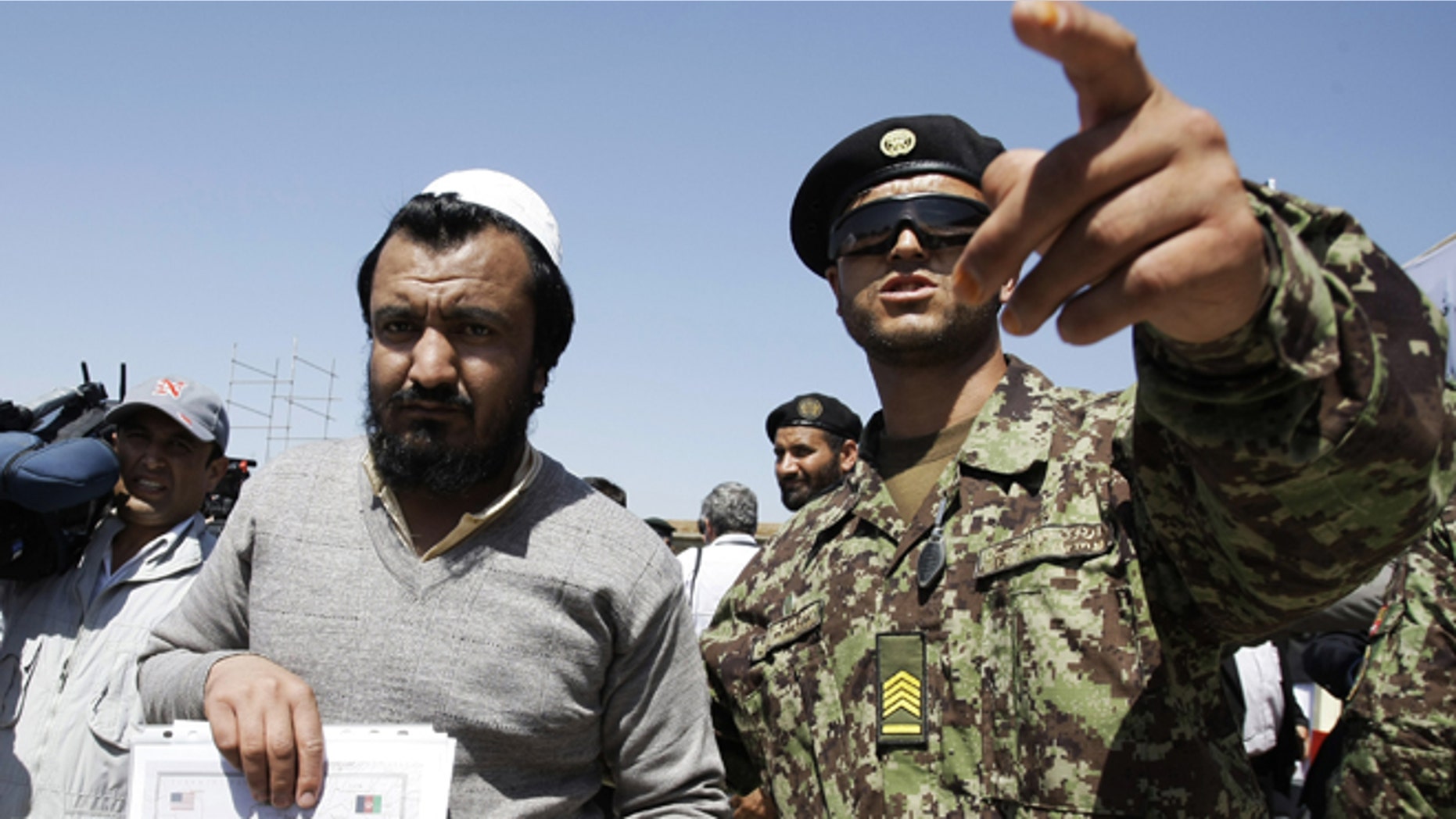 Sept. 10, 2012: An Afghan soldier, right, escorts a released prisoner, Mohammad Karim, following a hand over ceremony of U.S.- run prison to Afghan government in Bagram north of Kabul, Afghanistan.