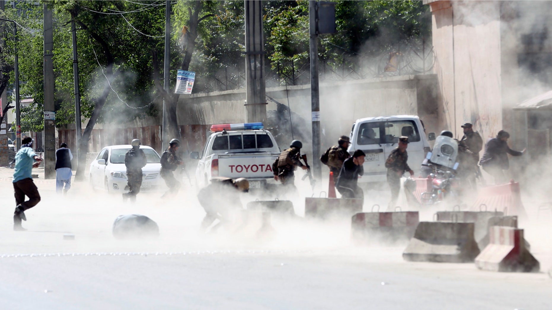 Afghan security forces run from a second suicide attack in Kabul Monday.