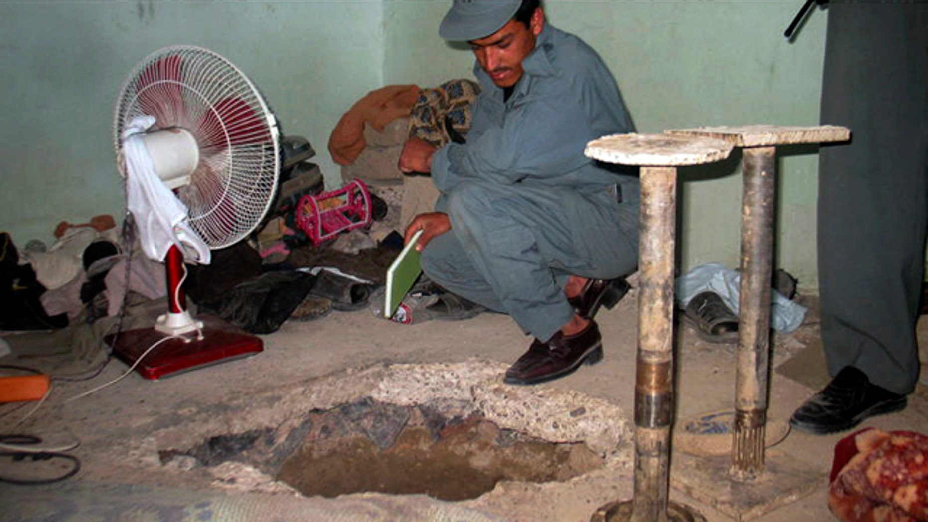An Afghan policeman takes a look at the opening of tunnel at the main prison in Kandahar, Afghanistan, which prisoners escaped through on Monday, April 25, 2011. Taliban insurgents dug a more than 1,050-foot tunnel underground and into the main jail in Kandahar city and whisked out more than 450 prisoners, most of whom were Taliban fighters, officials and the insurgents said Monday. (AP)