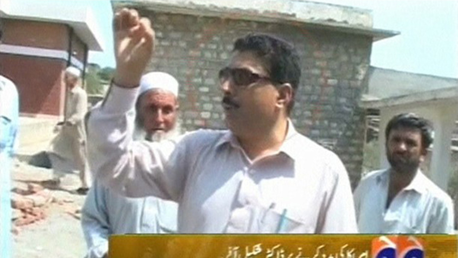 Pakistani doctor Shakil Afridi talks with people outside a building at an unknown location in Pakistan in this still image taken from file footage released May 23, 2012.