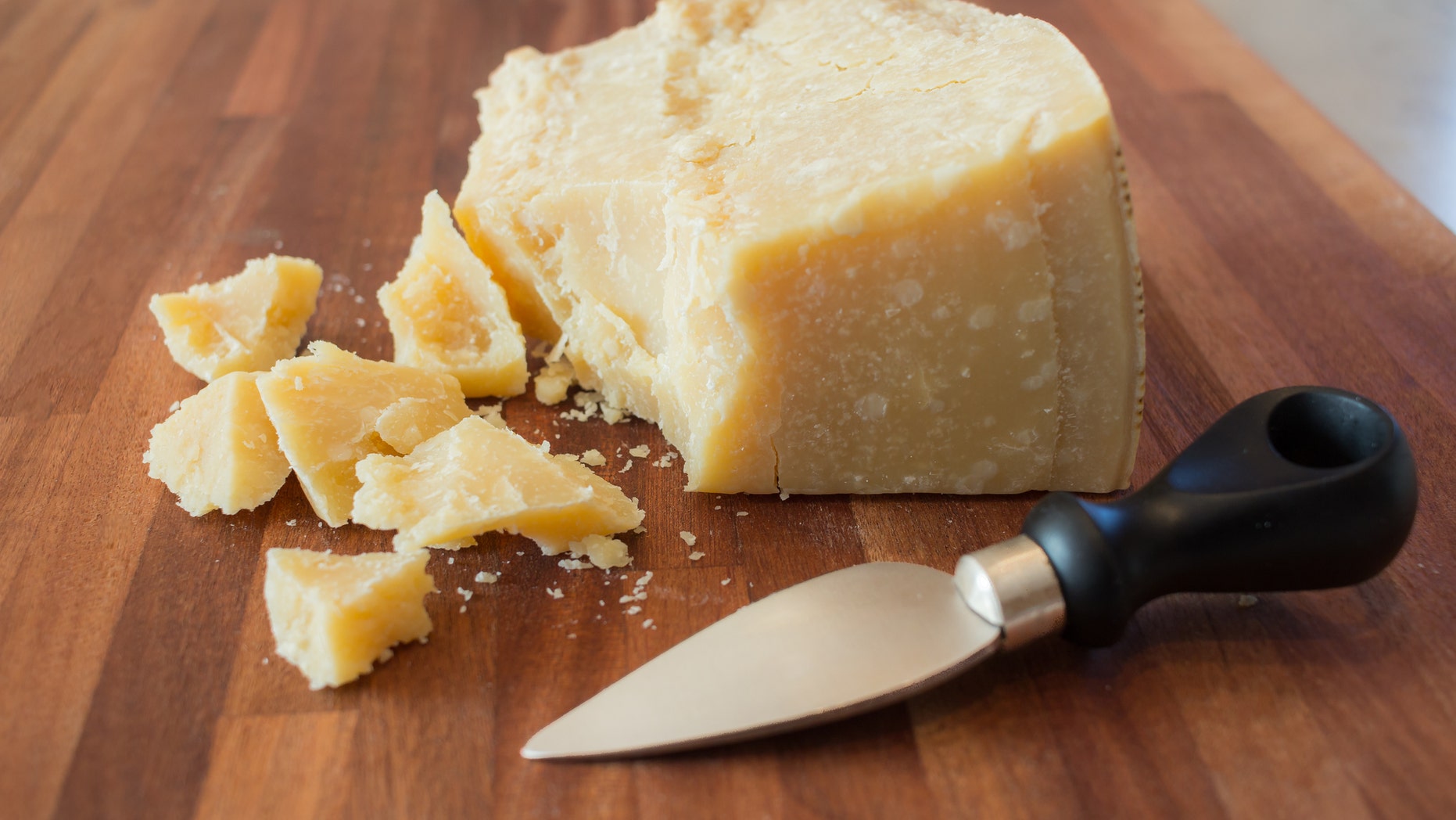 pieces of parmesan cheese on a wooden cutting board