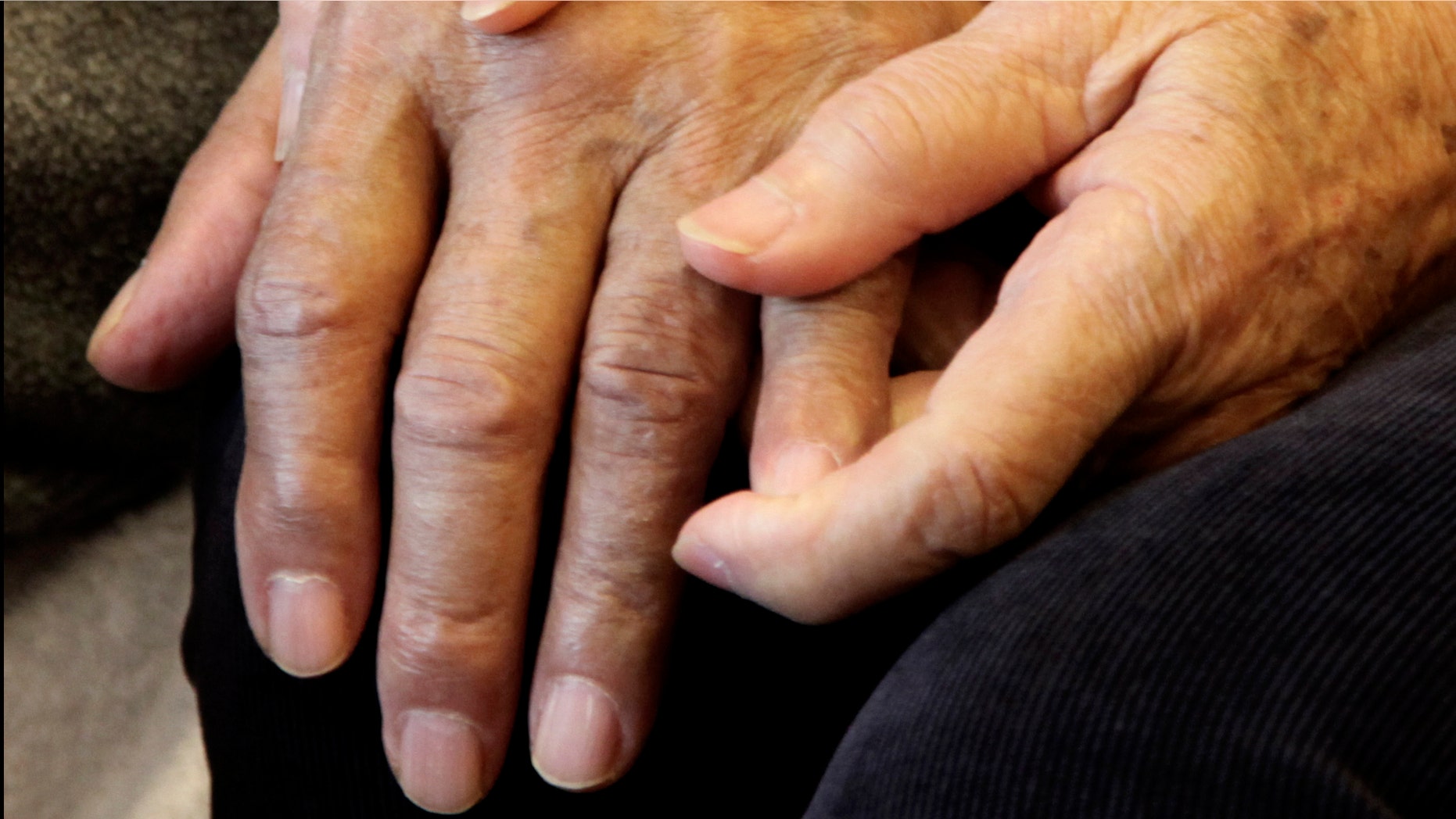 Shou-Mei Li holds the hand of her husband Hsien-Wen Li, who is an Alzheimer's patient, at their home in San Francisco, in this photo taken, Thursday, Sept. 1, 2011. Dementia is poised to become a defining disease of a rapidly aging population _ and a budget-busting one for Medicare, Medicaid and families. The Obama administration is developing the first national Alzheimer's plan to combine research aimed at fighting dementia with help for caregivers. Around the country, thousands of families are pleading for changes to improve early diagnosis and help keep loved ones at home instead of in nursing homes. (AP Photo/Ben Margot)