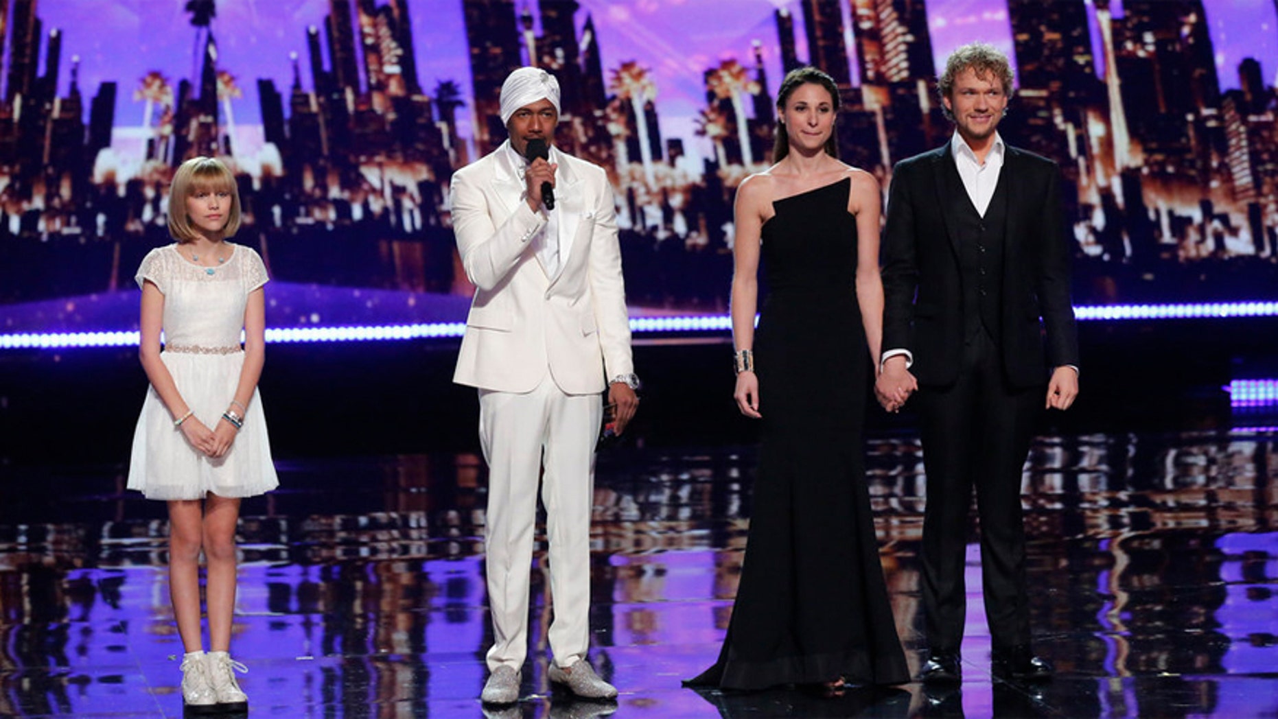 Grace VanderWaal (left) and The Clairvoyants (right) wait to hear host Nick Cannon (center) announce the "America's Got Talent" winner.