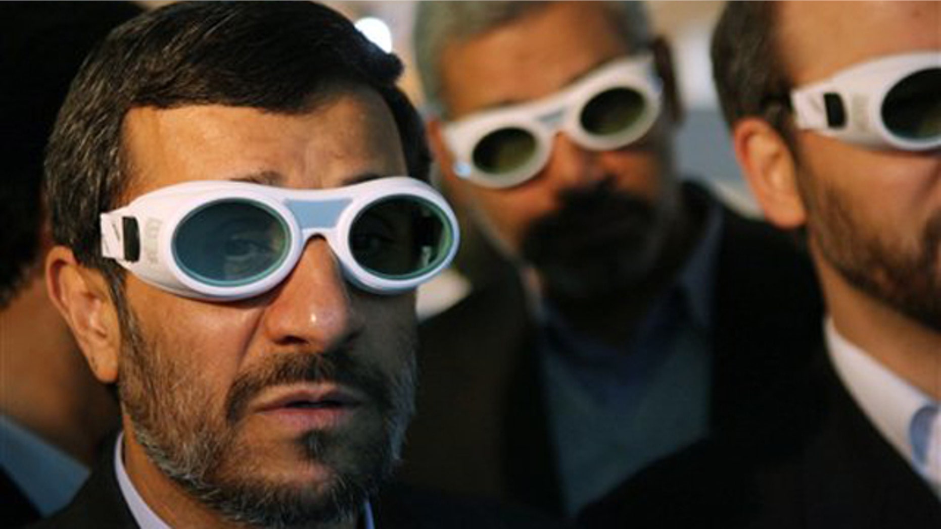 In this Feb. 7 file photo, Iranian President Mahmoud Ahmadinejad wears eye protection goggles as he visits an exhibition of Iran's laser science in Tehran.
