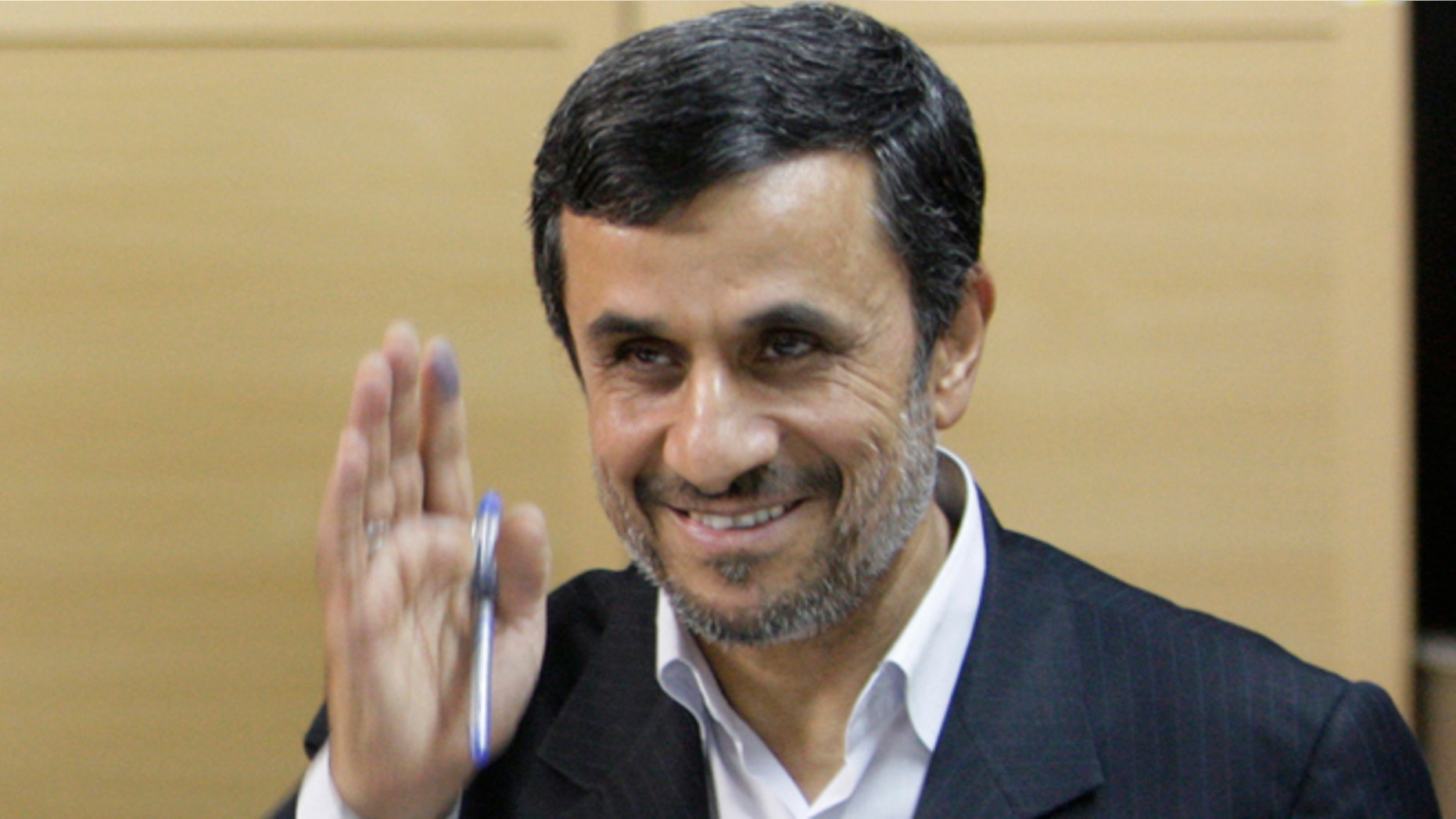 May 4, 2012: Iranian President Mahmoud Ahmadinejad waves to media after casting his vote for the parliamentary runoff elections at a polling station in Tehran, Iran.