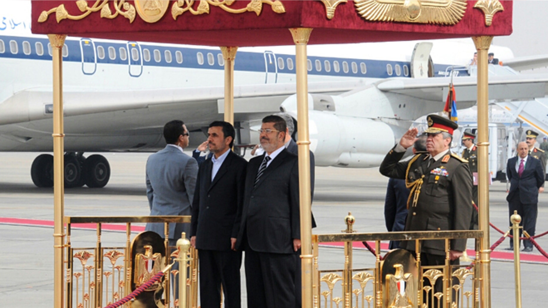 Feb. 5, 2013: In this image released by the Egyptian Presidency, Iran's President Mahmoud Ahmadinejad, center, and Egyptian President Mohammed Morsi, center right, participate in an arrival ceremony at the airport in Cairo, Egypt.