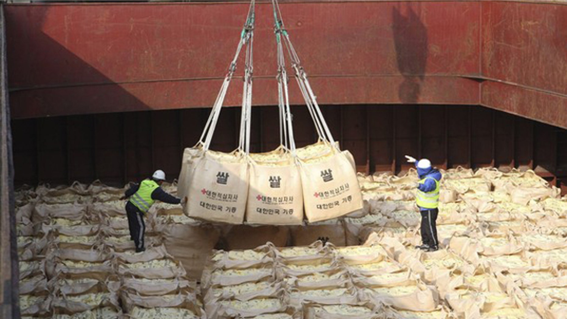 Workers load packs of rice as food aid for flood-stricken North Koreans onto a ship at a port in Gunsan, about 168 miles south of Seoul, Oct. 22, 2010.