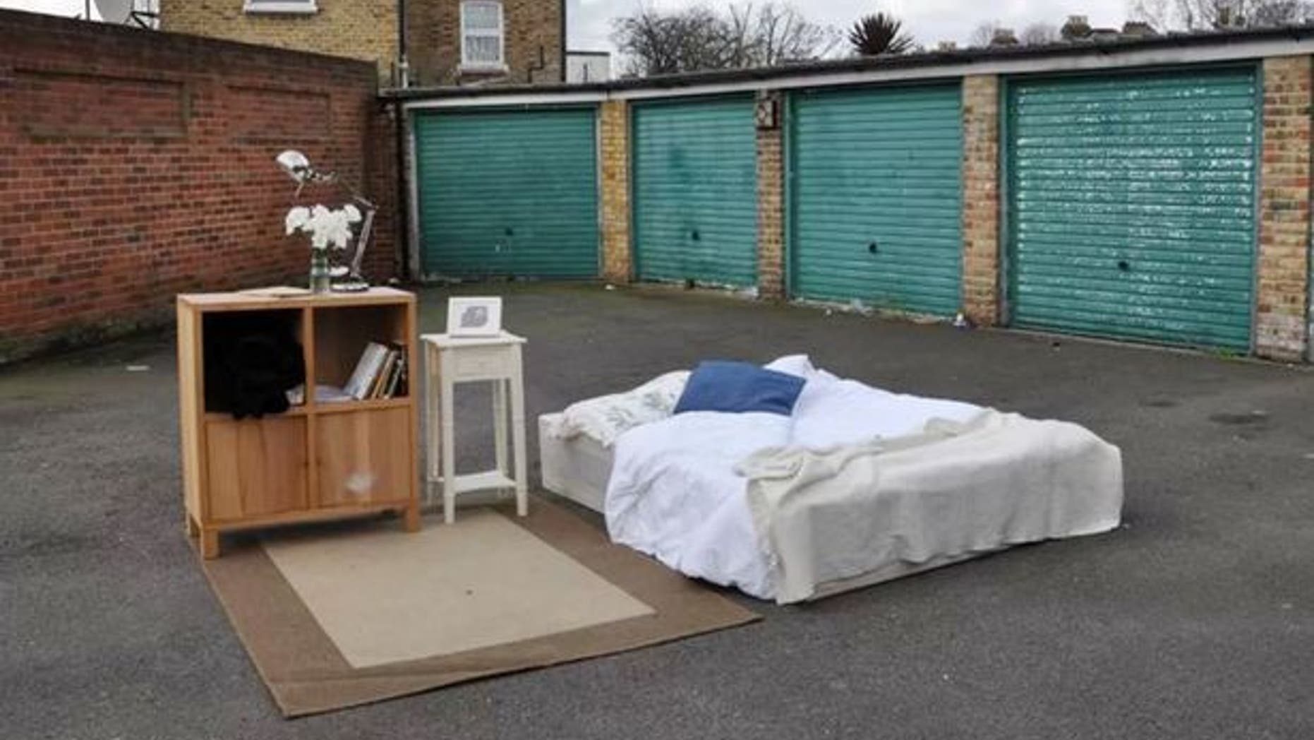 An airy "room" with a bed, cabinet nightstand... and plenty of space to walk around.
