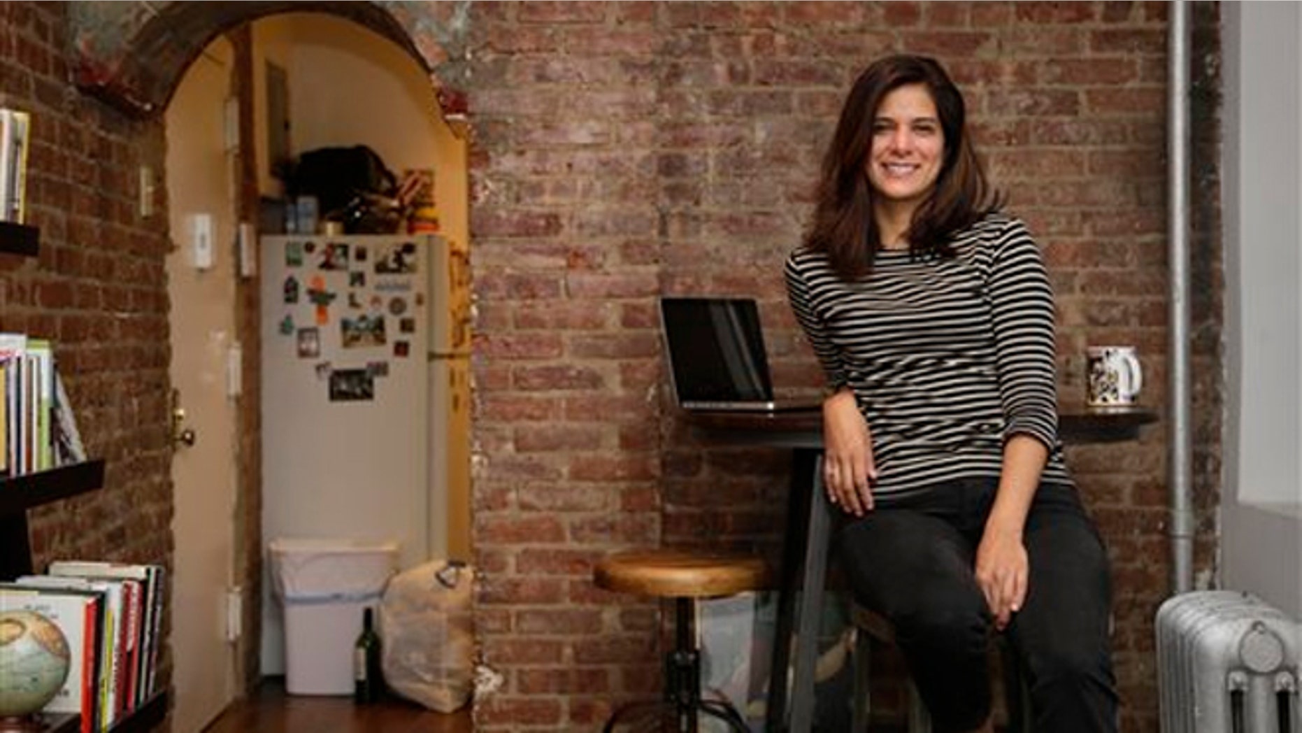 Oct. 10, 2013: Mishelle Farer poses for picture in her apartment, where she rents a room on Airbnb, in New York.