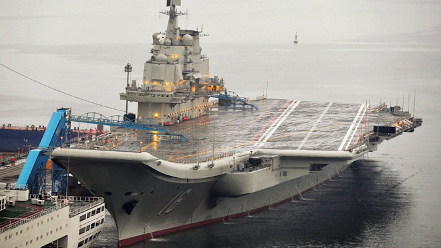 FILE 2012: China's first aircraft carrier, which was renovated from an old aircraft carrier that China bought from Ukraine in 1998, is seen docked at Dalian Port.