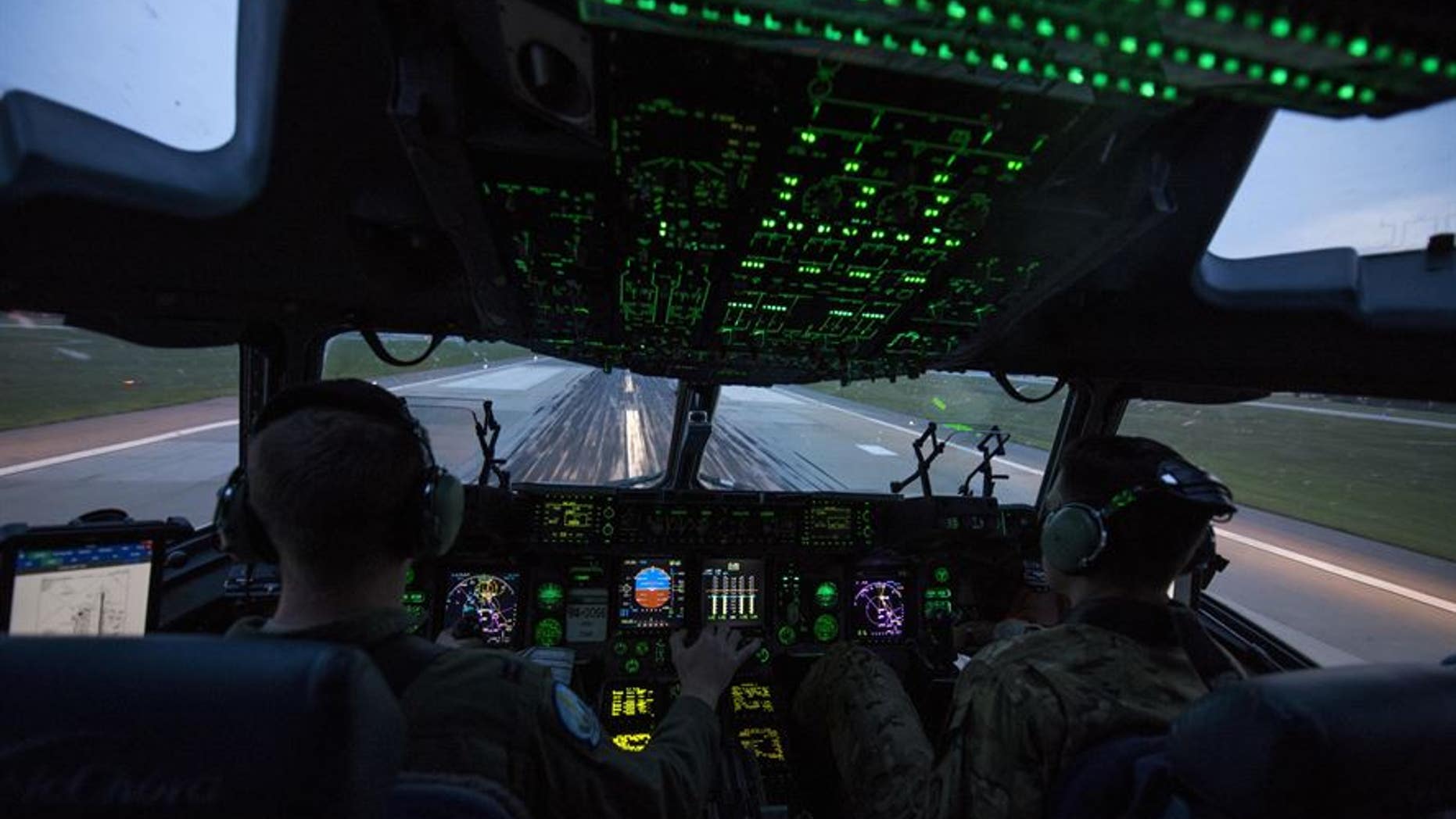 Capts. Wes Sloat (left) and Jared Barkemeger, 7th Airlift Squadron pilots, operate a C-17 Globemaster III during takeoff from the flight line of Fort Bragg, N.C., during Operation Panther Storm, July 27, 2017.