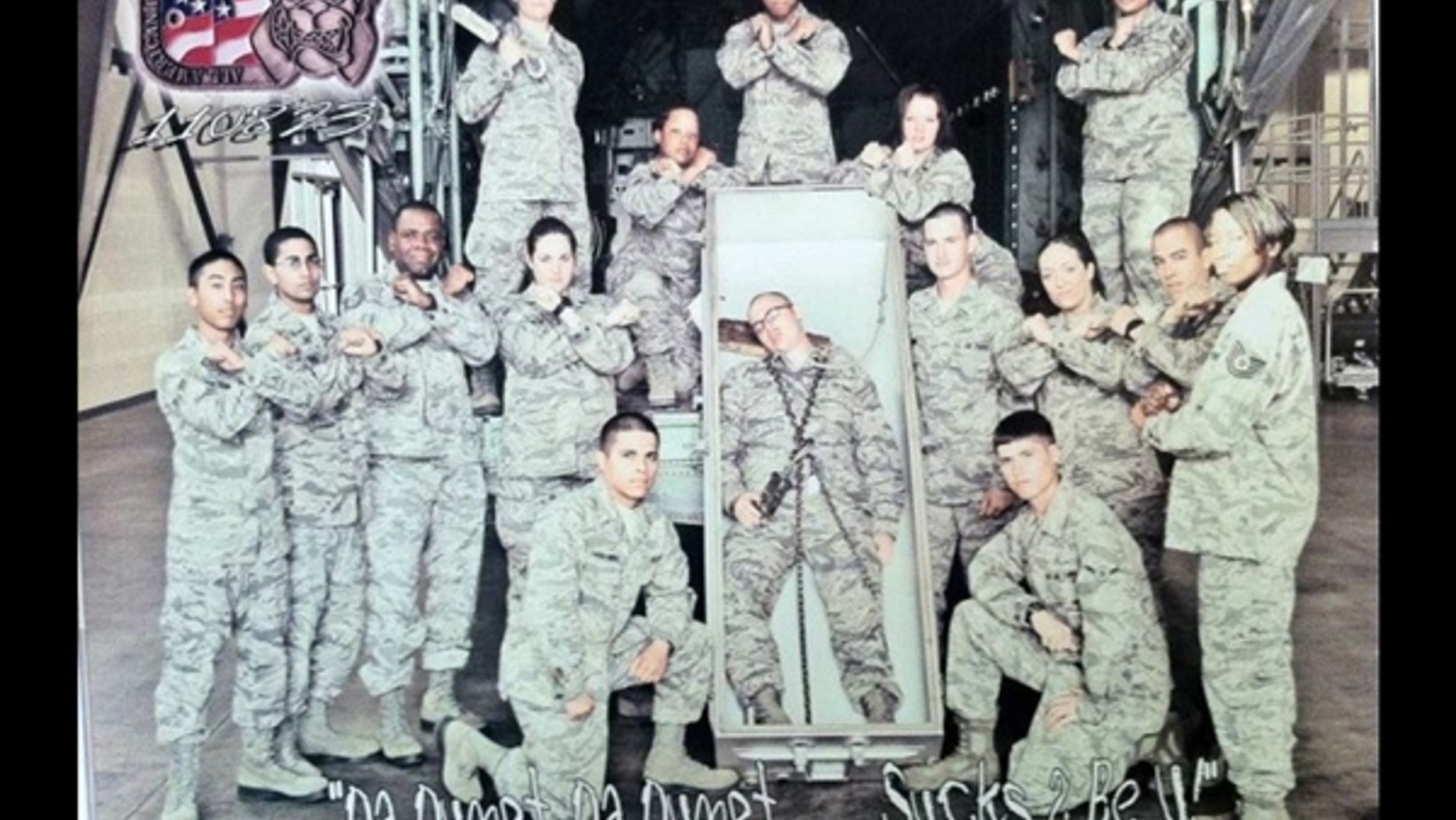 Air Force officials say they are investigating this photo of 15 airmen posing with another airman pretending to be dead and lying in an open casket with a noose around his neck.
