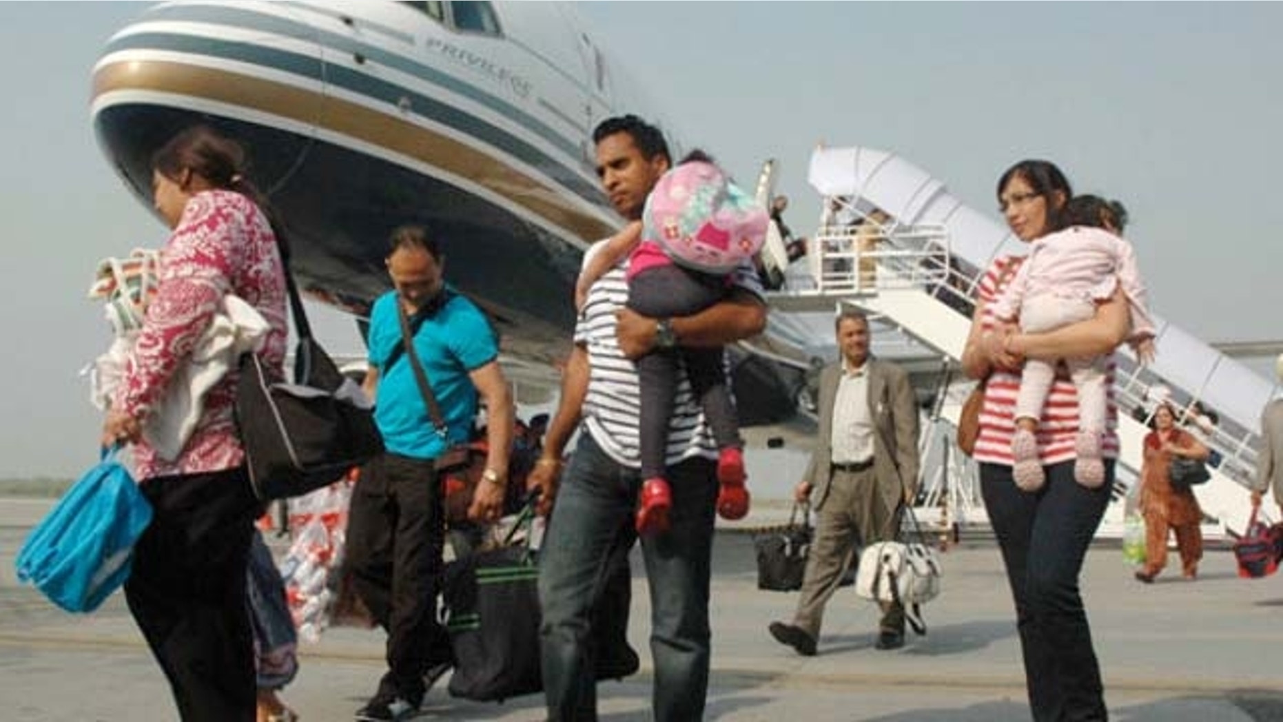 October 2, 2011: Indian passengers arrive from Austria at the Rajasansai International Airport on a Comtel Air flight in Amritsar.