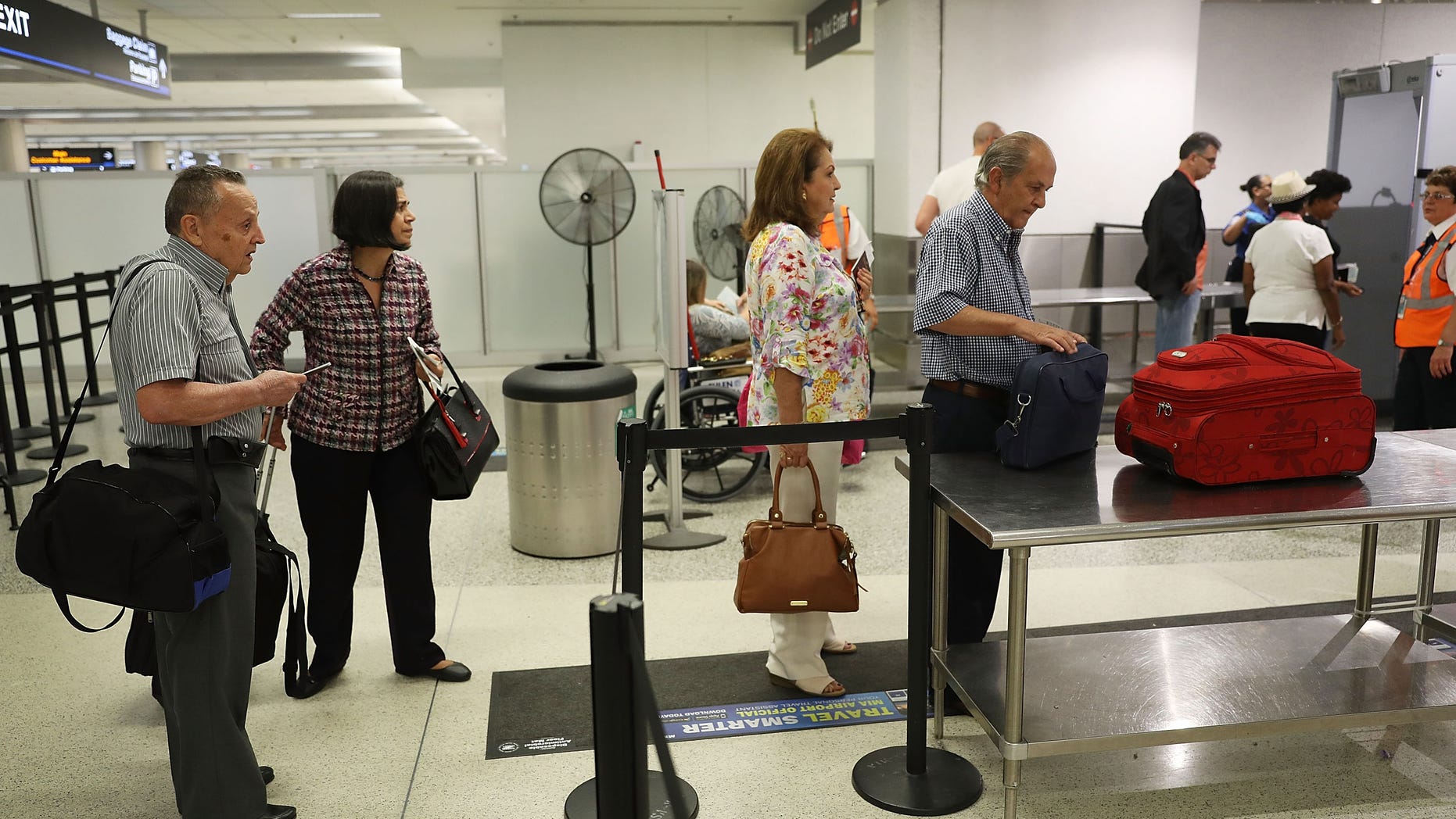 MIAMI, FL - JUNE 02: Travelers go through the TSA PreCheck security point at Miami International Airport on June 2, 2016 in Miami, Florida. As the busy summer travel season heats up the Transportation Security Administration is encouraging people to sign up for the TSA PreCheck program to save time going through the airports security lines. Those enrolled in the program can leave their shoes, light outerwear and belt on during the terminal screening process as well as keeping their laptop in the carry-on suitcase without having to remove them at the checkpoint. (Photo by Joe Raedle/Getty Images)