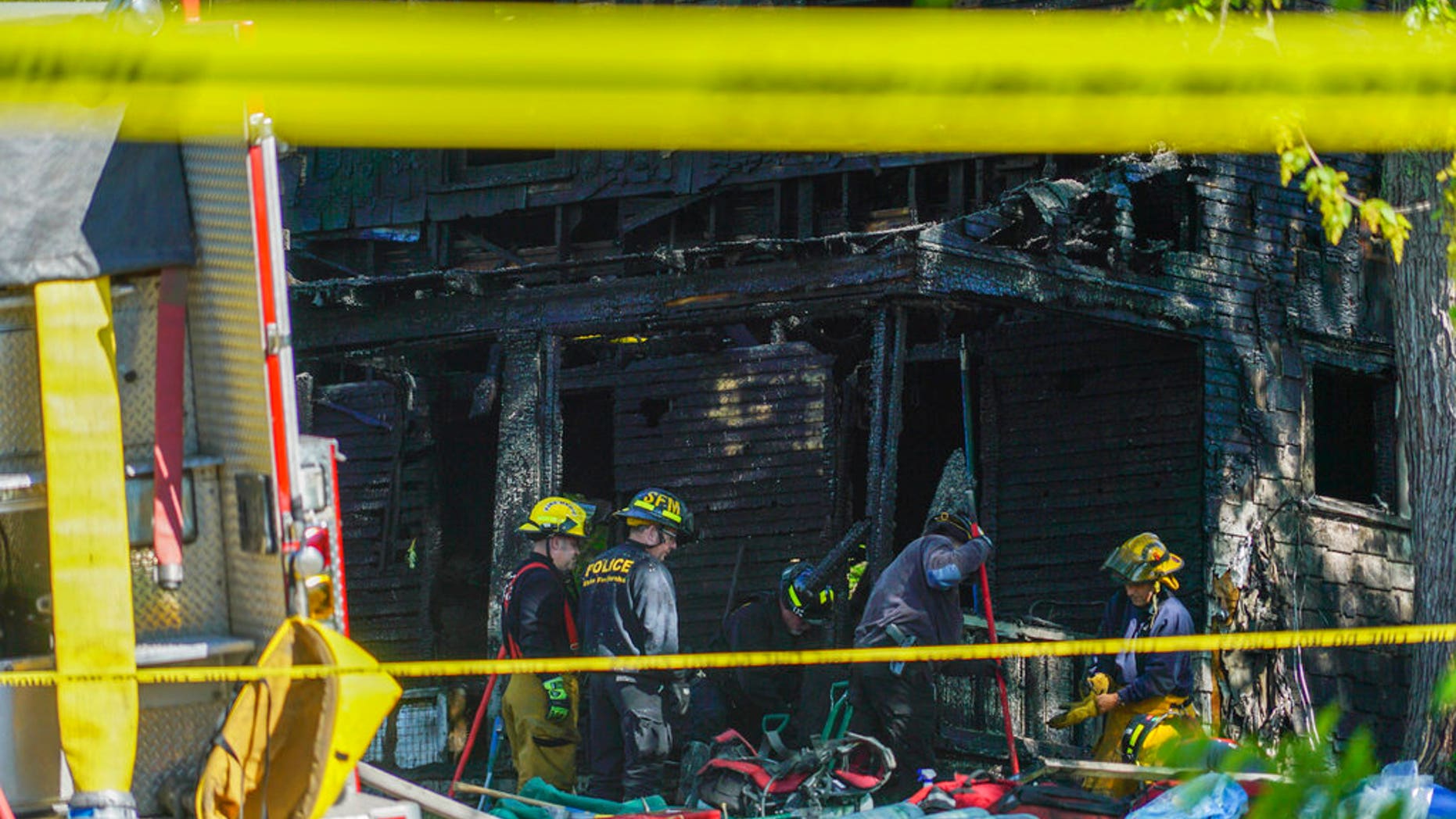Firefighters investigate the remains of a burned home in Akron, Ohio on Monday, May 15, 2017. Firefighters said multiple people died in the fire at the home. (AP photo/Dake Kang)