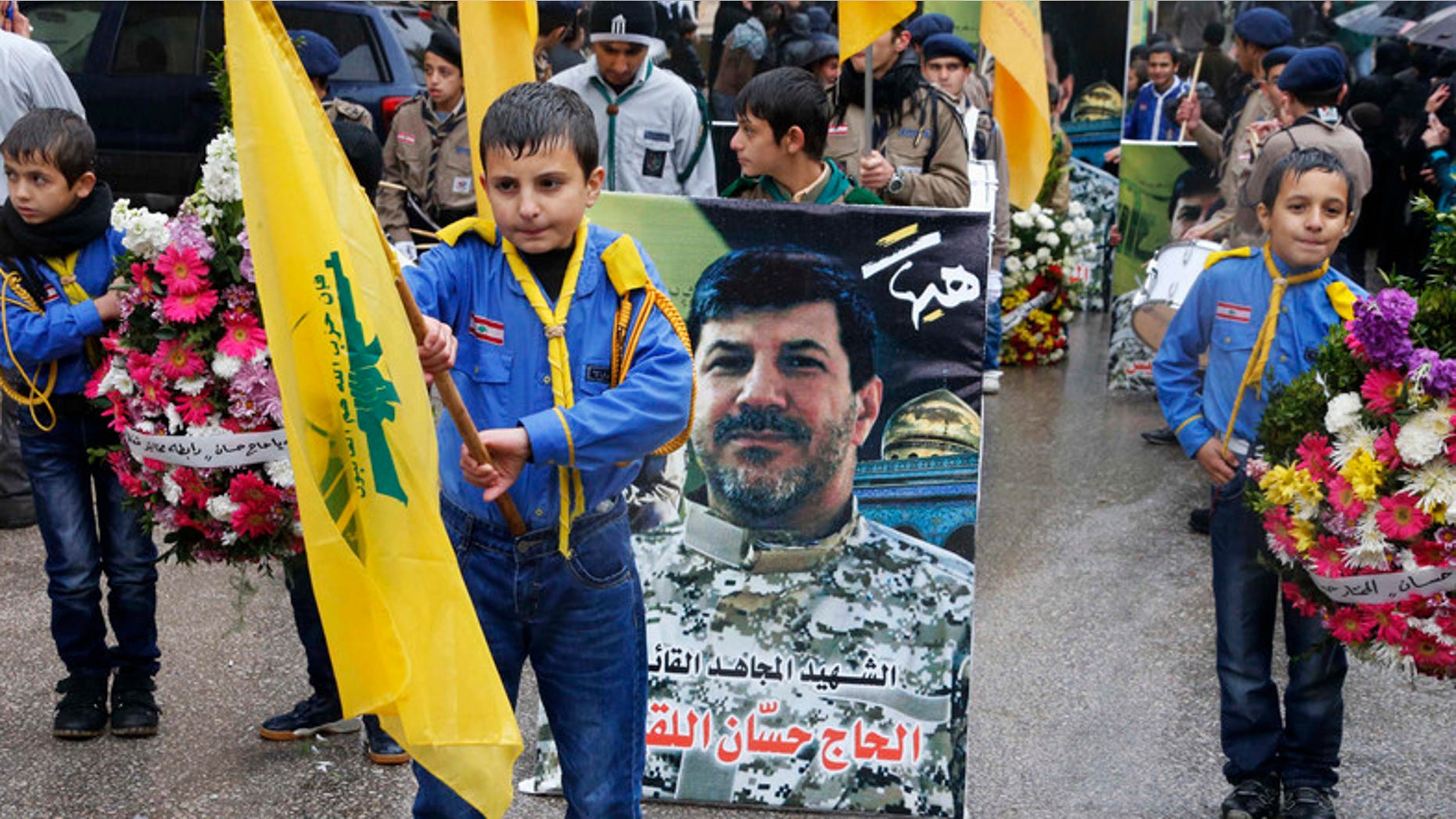 Hezbollah boy scouts carry the party flags and a picture of Hezbollah commander Hassan al-Lakkis during his funeral in Baalbeck, in Lebanon's Bekaa valley. (Reuters)