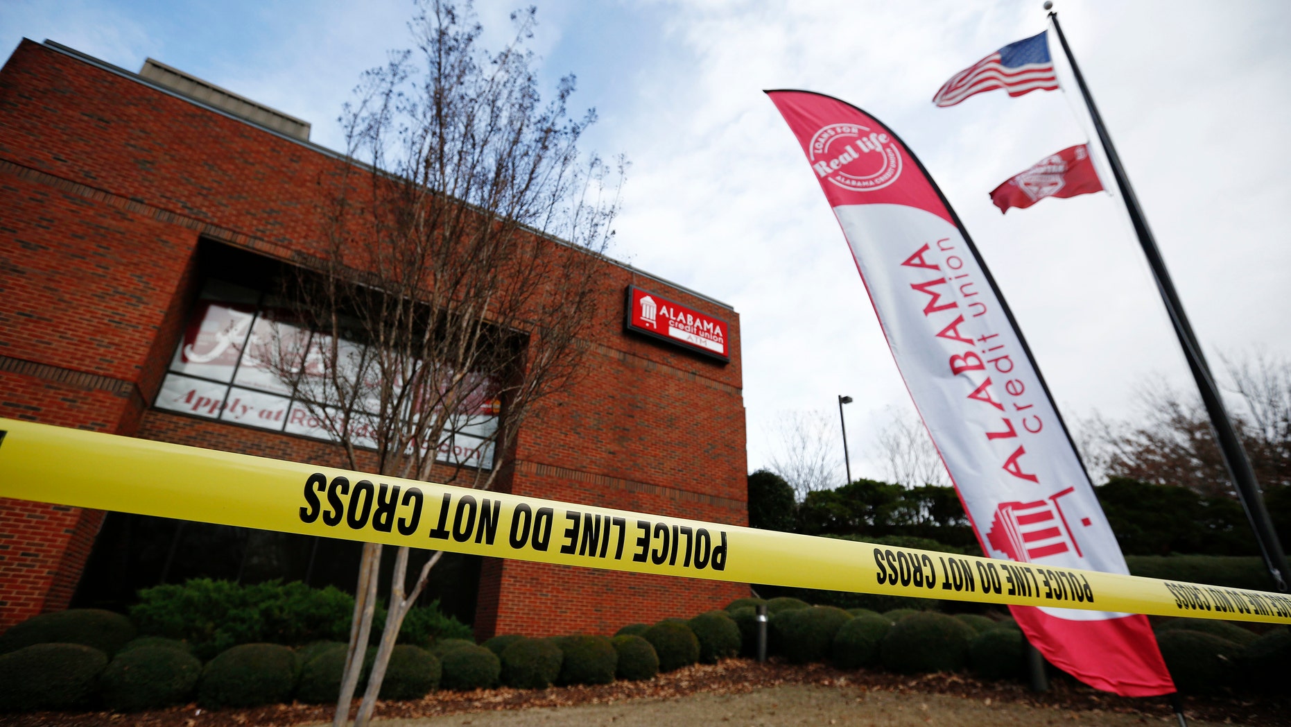 Police tape surrounds the Alabama Credit Union building after reports of a hostage standoff, Tuesday, Jan. 10, 2017, in Tuscaloosa, Ala. A group of hostages was freed, unharmed, and a man with a gun was arrested Tuesday at the credit union branch near the University of Alabama, police said. (AP Photo/Brynn Anderson)