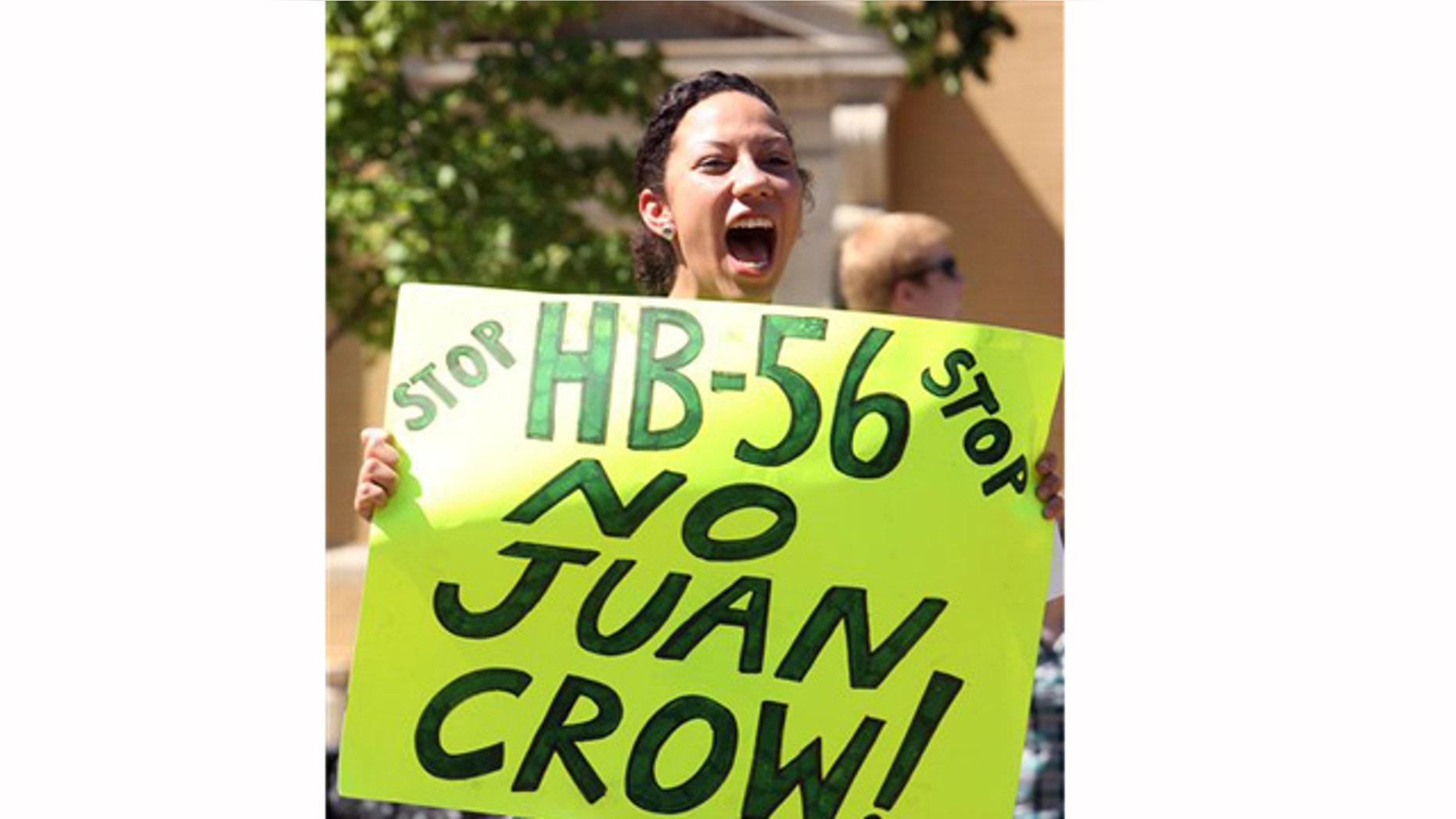 Ashley Hendricks, a University of Alabama student from Huntsville, holds a sign and chants while protesting HB-56 on Wednesday, Sept. 28, 2011. Approximately 40 students gathered for a protest of the immigration bill on the University of Alabama campus in Tuscaloosa, Ala. (AP Photo/Tuscaloosa News, Robert Sutton)