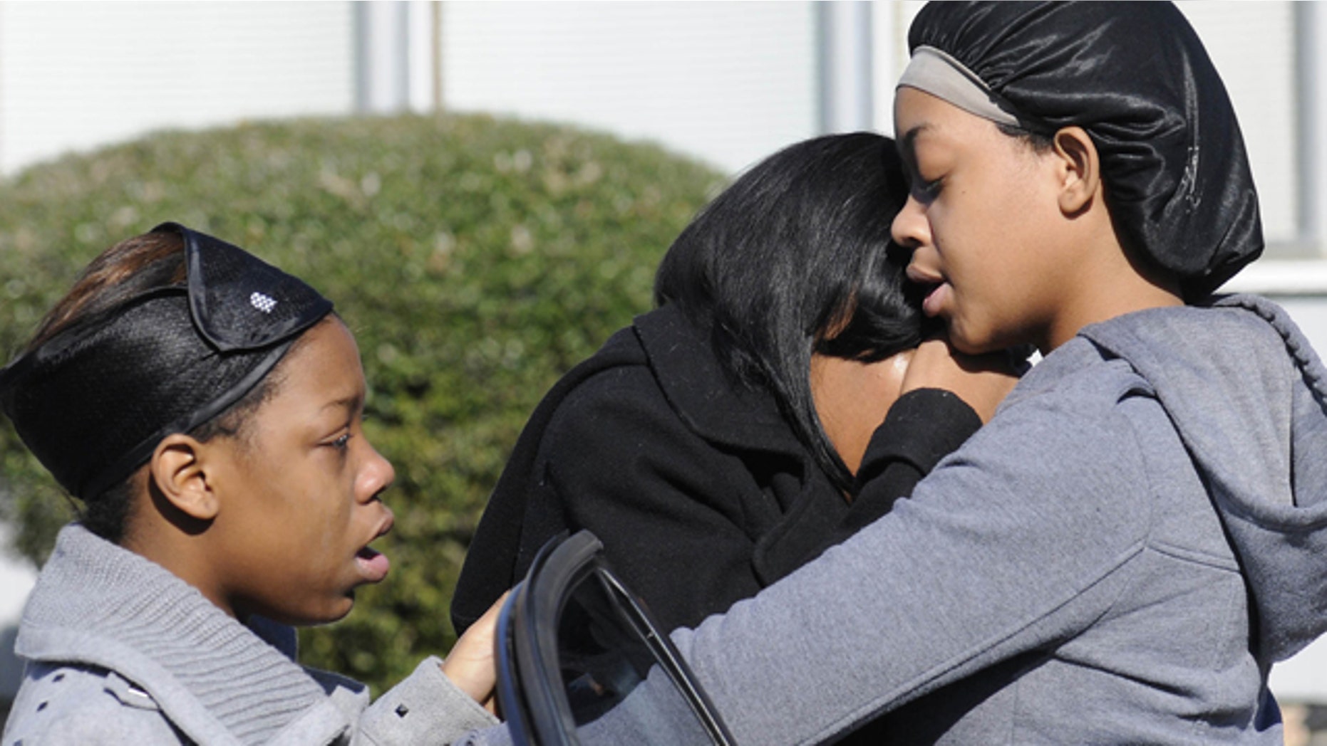 Jan. 29, 2012: Ravenn Carlton, center, wife of one of the five people found dead is comforted by Nakia Carlton, left, and Khalena Carlton, right, near the scene where five people were found dead inside a house in Birmingham, Ala.