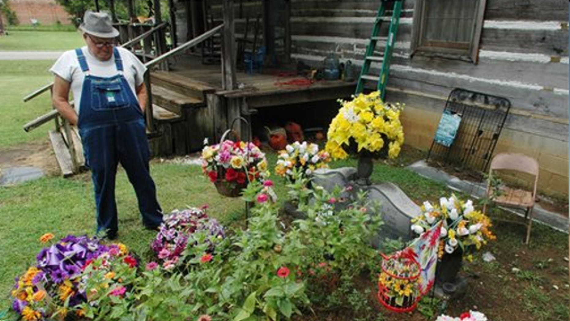 Aug. 10, 2012: James Davis, 73, stands over the grave of his wife, Patsy, in the front yard of the home they shared in Stevenson, Ala.