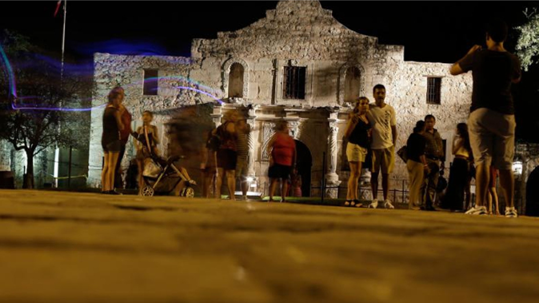 FILE: Aug. 1, 2013: Tourists make a late evening visit to the Alamo, in San Antonio. The Texas General Land Office, which took control of the Alamo in 2011, approved a gun rights rally for Saturday, Oct. 19, 2013, breaking with tradition that had kept demonstrations off the hallowed ground.