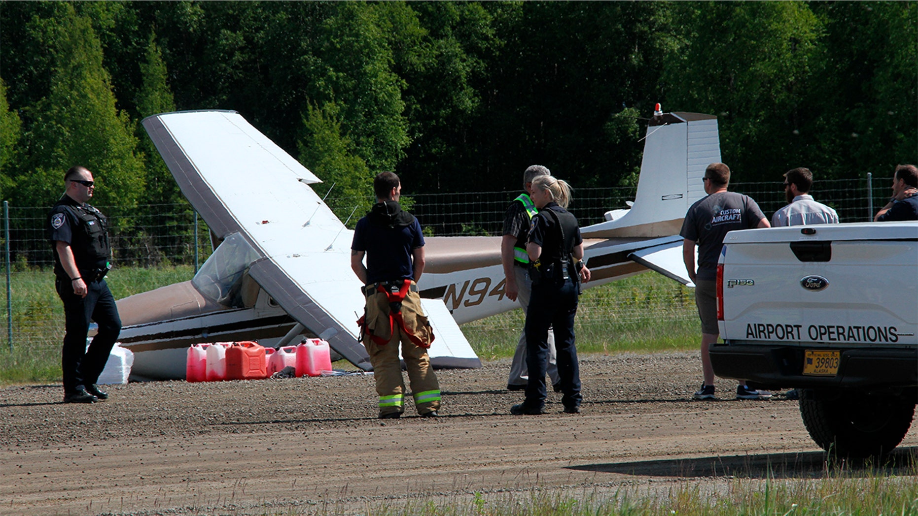 Ted Stevens Anchorage International Airport fire department and National Transportation Safety Board personnel respond to a damaged aircraft at Lake Hood Seaplane Base on Wednesday in Anchorage, Alaska.