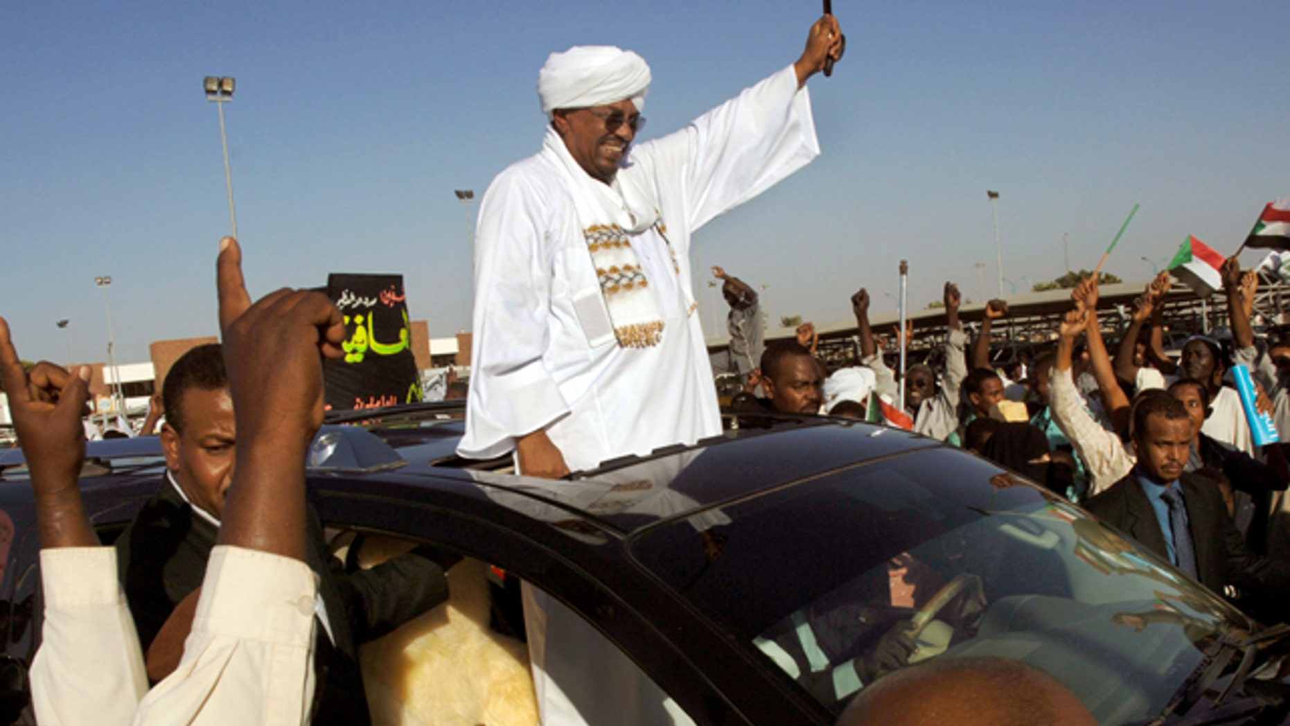 Nov. 14, 2012: Sudanese President Omar al-Bashir waves to people after his arrival at the Khartoum airport in Sudan. Sudanese state television says al-Bashir has returned to the country after undergoing surgery in Saudi Arabia. (AP)