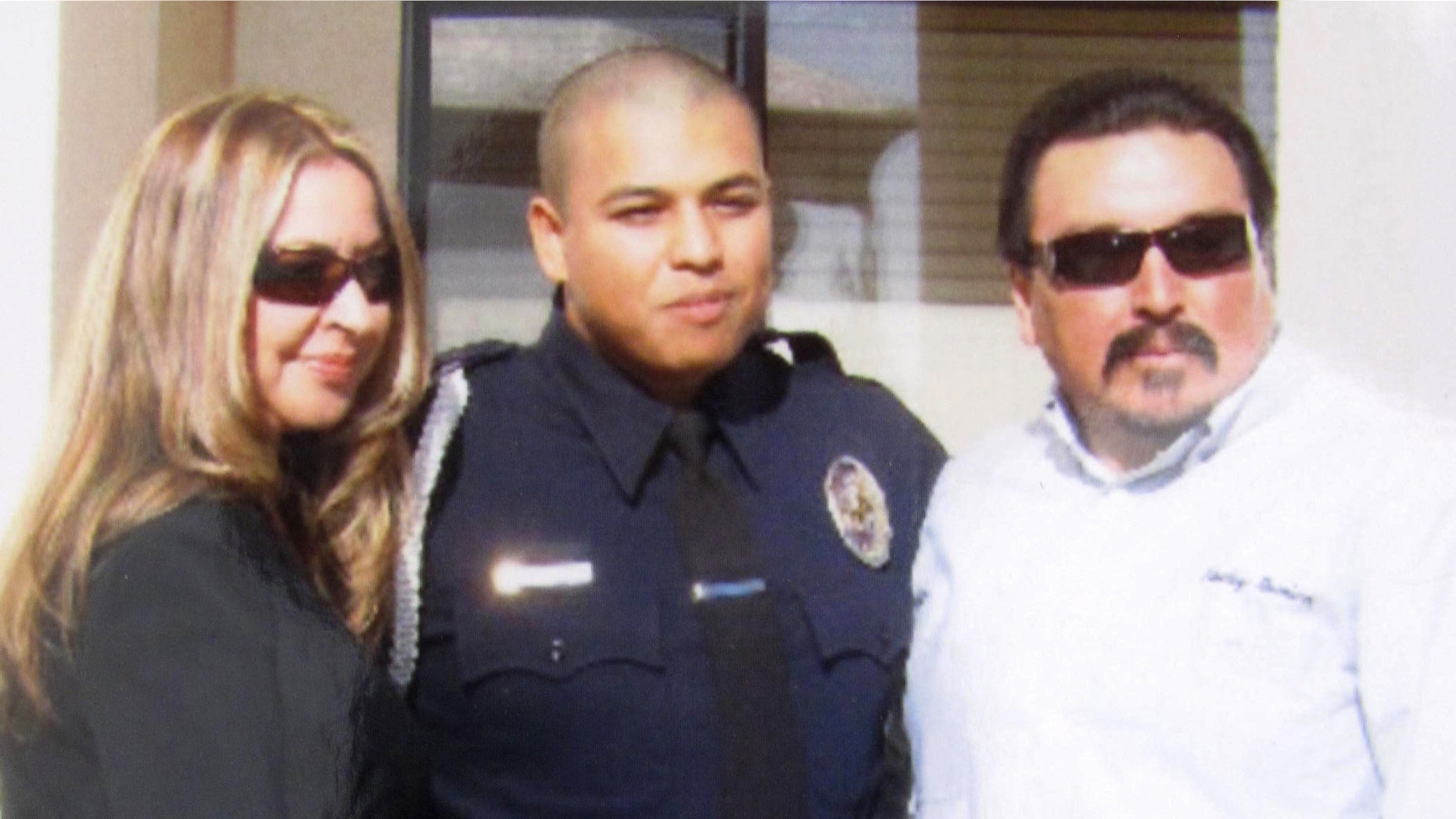 Officer Albert Covarrubias Jr. flanked by his father, Albert Sr., and his step-mother, Chela, on the day four years ago that he graduated from the police academy.