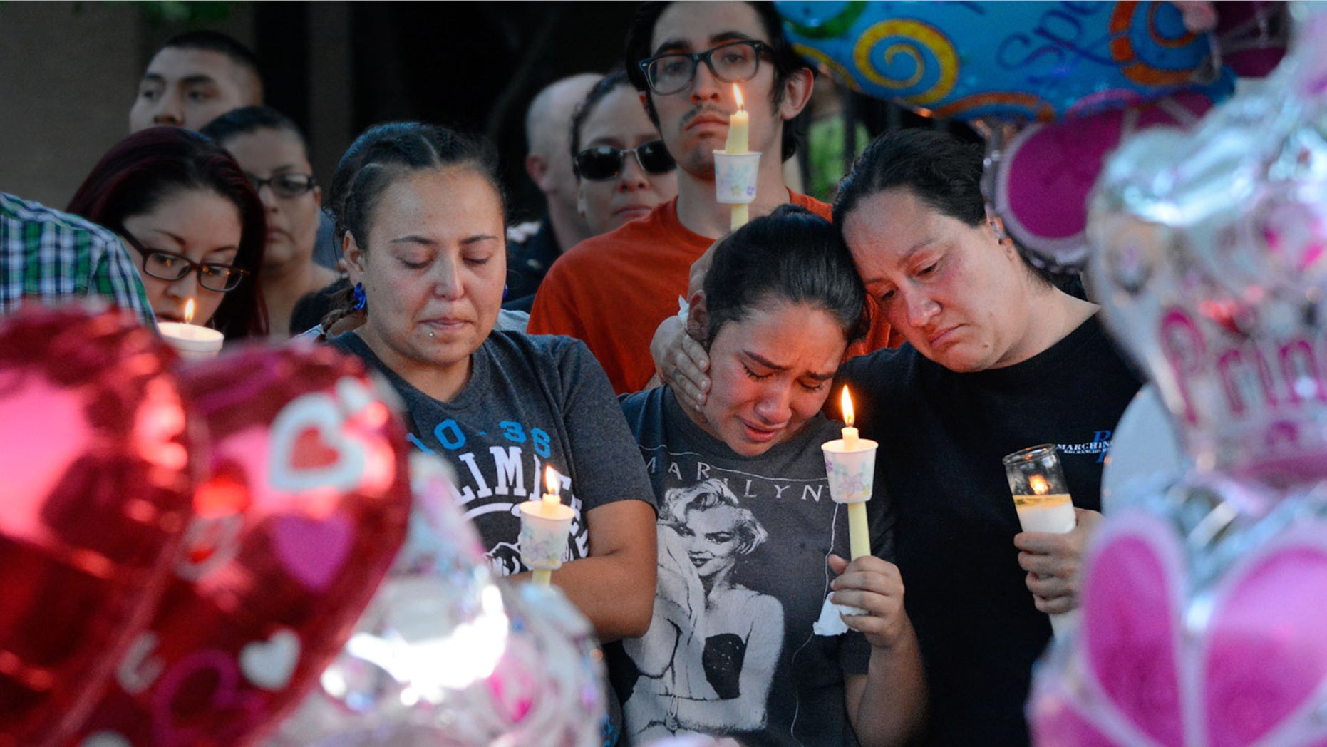 Aug. 25, 2016: Nicole Maldonado, Myriah Flores, and her mother Sharlene Benavidez attend a candlelight vigil for 10-year-old Victoria Martens at the apartment complex, in Albuquerque, N.M., where the young girl lived and was killed.